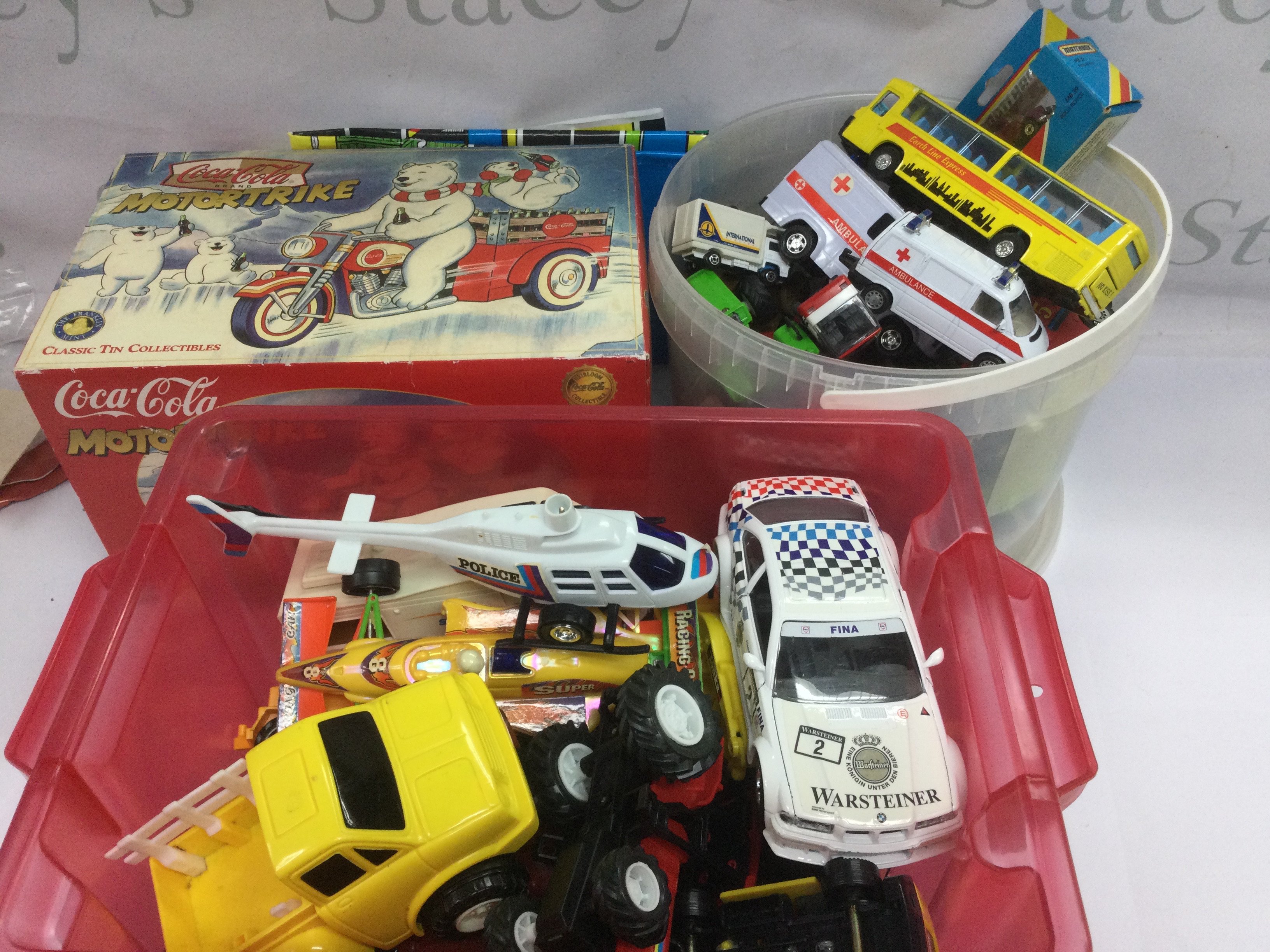 Two tubs of playworn vehicles plus a boxed Coca Cola motortrike. Shipping category D.