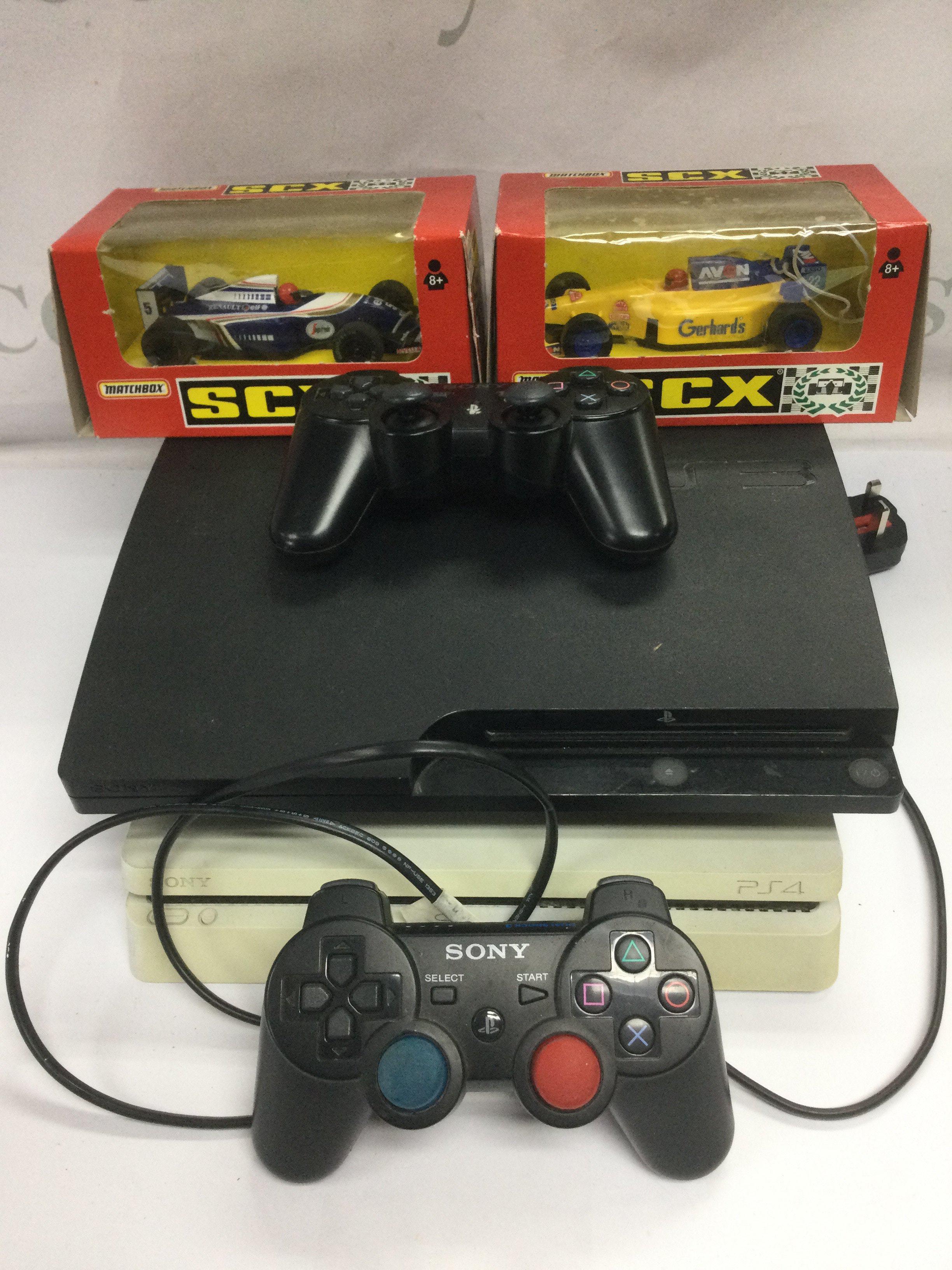 A Playstation PS3 and a PS4 with two controllers and two boxed Scalextric F1 cars.