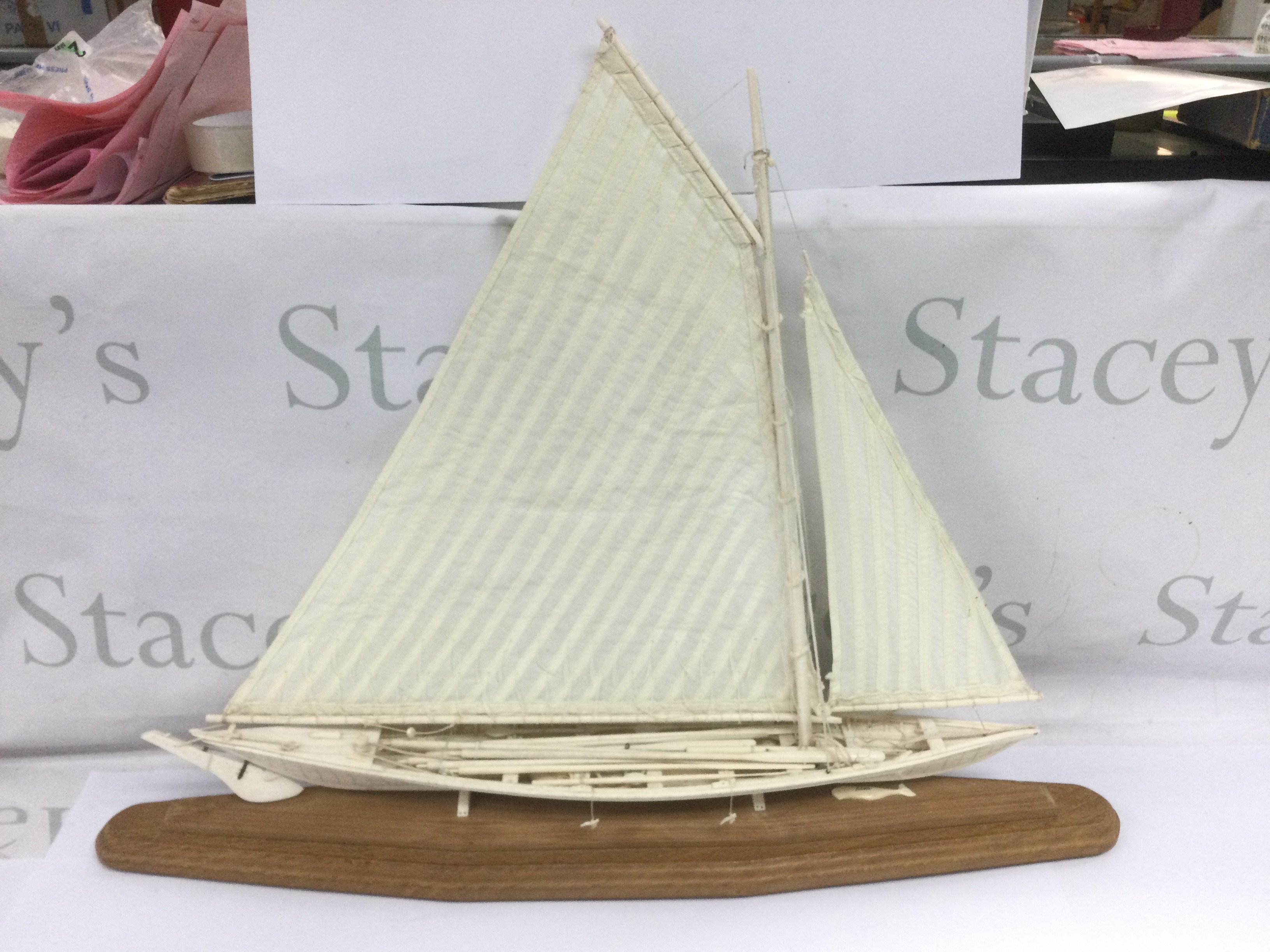 A whalebone model whaling boat complete with oars, ropes, spears etc and raised on a wooden base. Total length approx 60cm. Shipping category D.