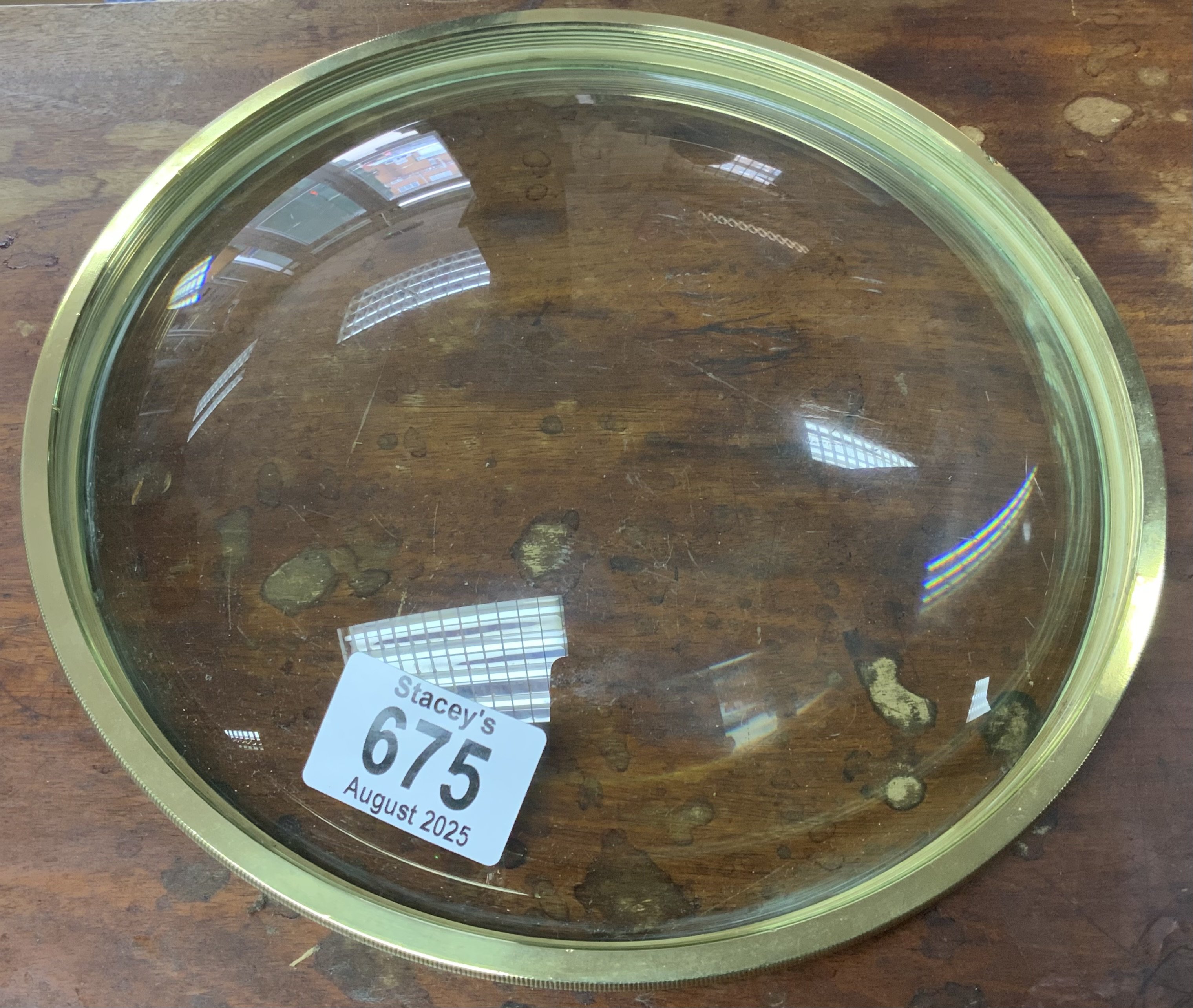 A large Convex magnifying lense with coin edge brass mount. 23cm Diameter.