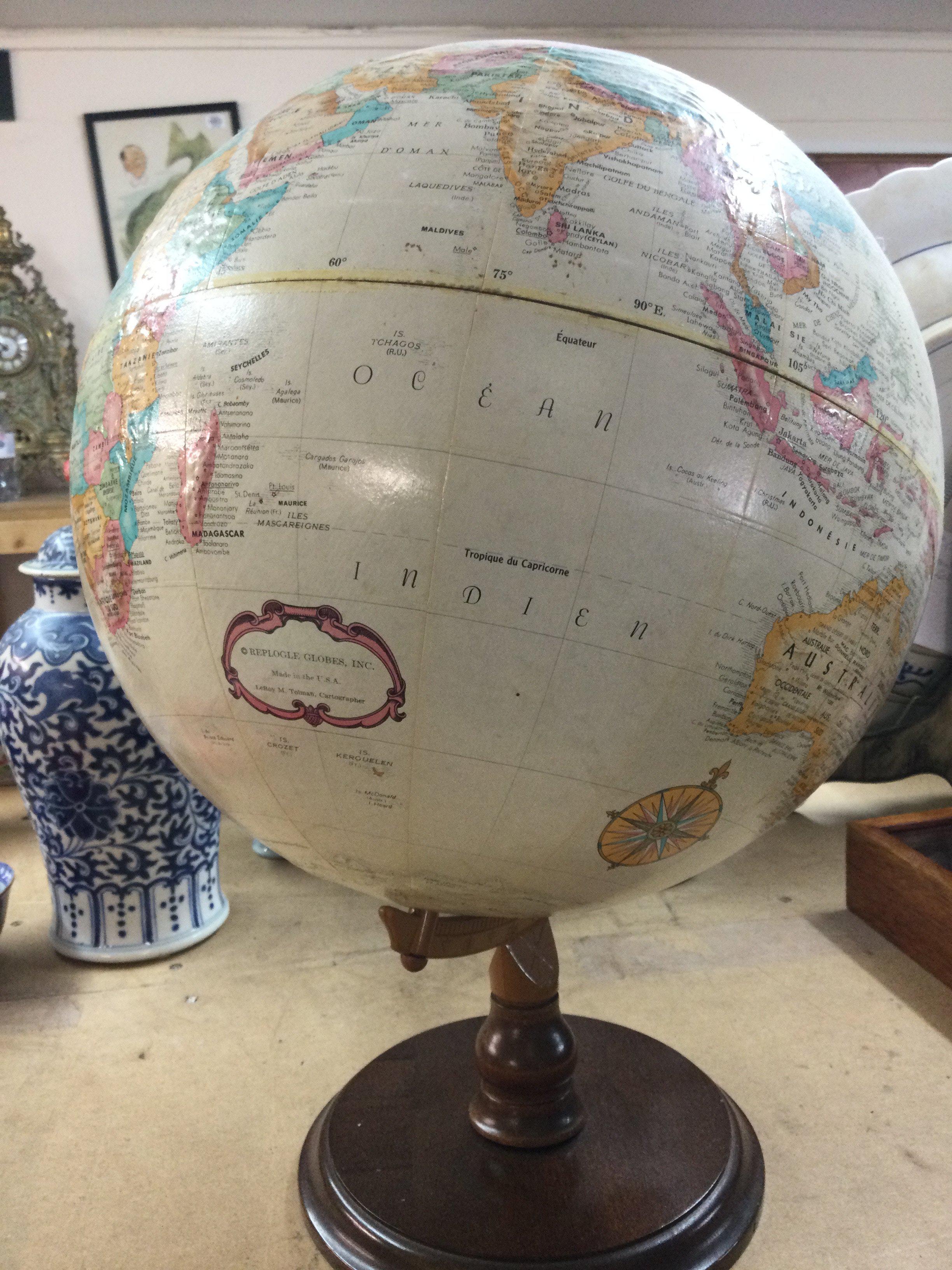 A Replogle globe on mahogany stand .