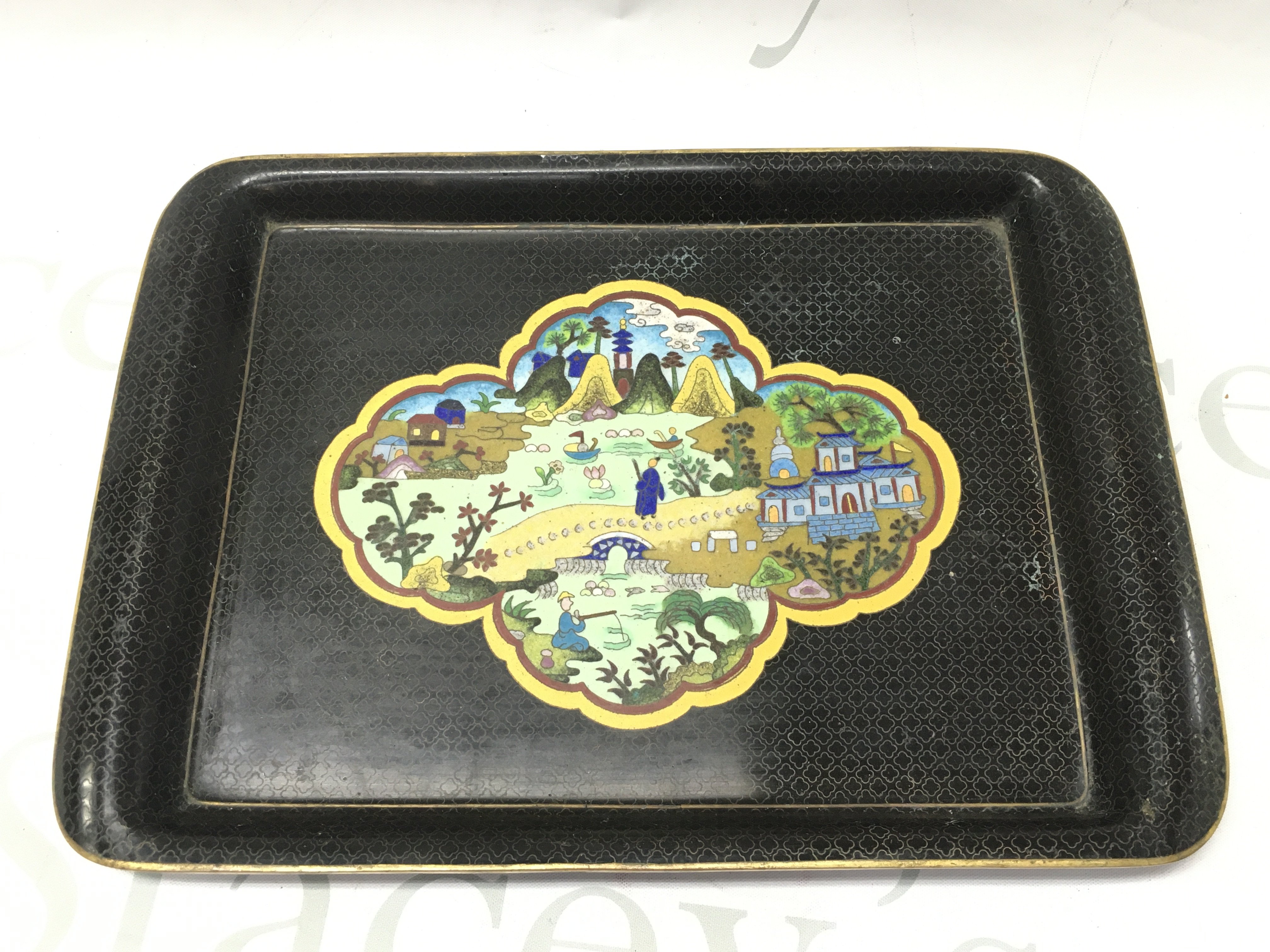 A Cloisonne tray with temple scene design and a blue glazed and gilt decorated base. Dimensions 31x22cm . Postage category B