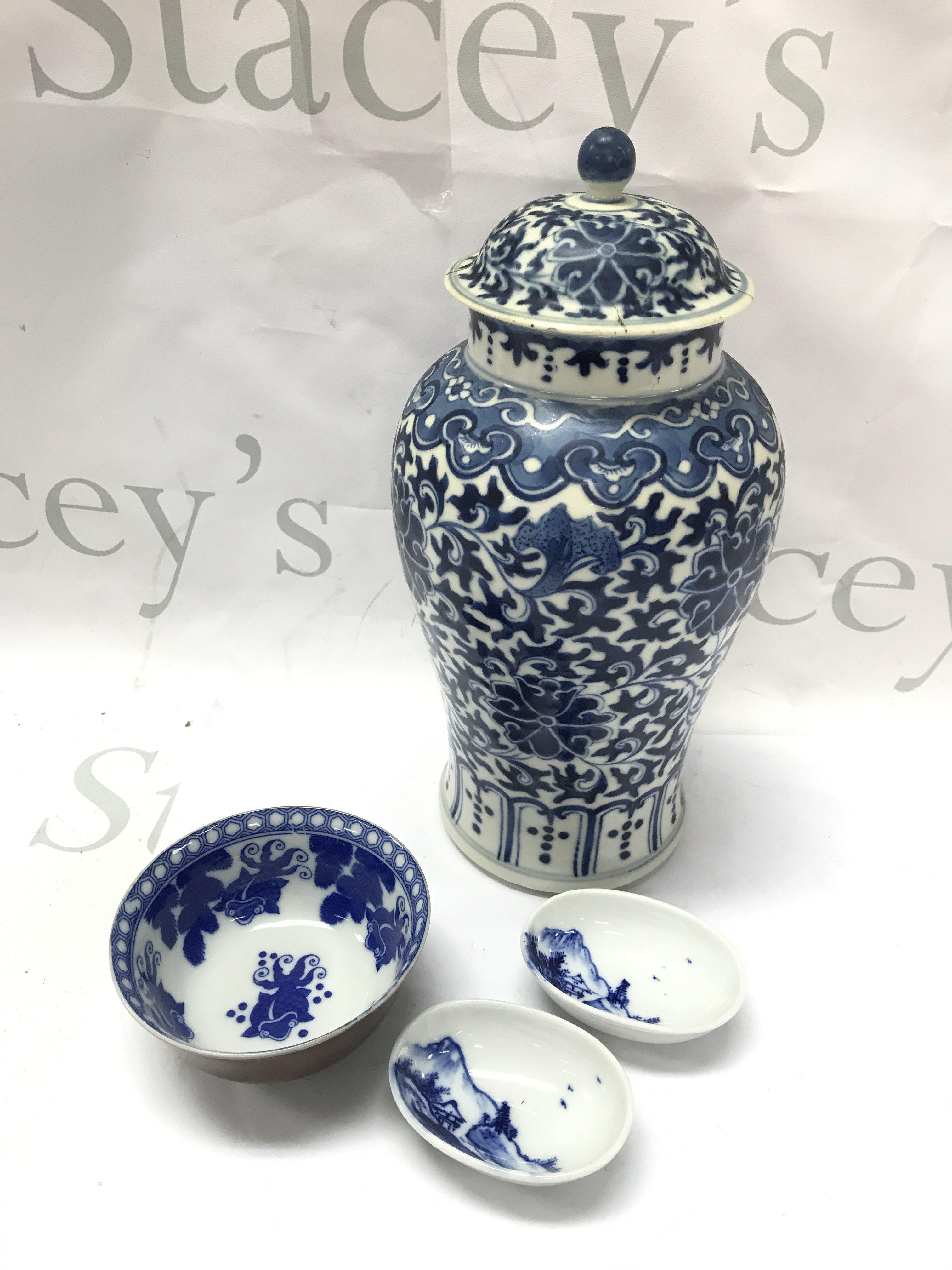 A Chinese blue and white vase with lid and four character mark at base (lid damaged and restored), koi blue and white bowl and two small bowls. This lot cannot be posted