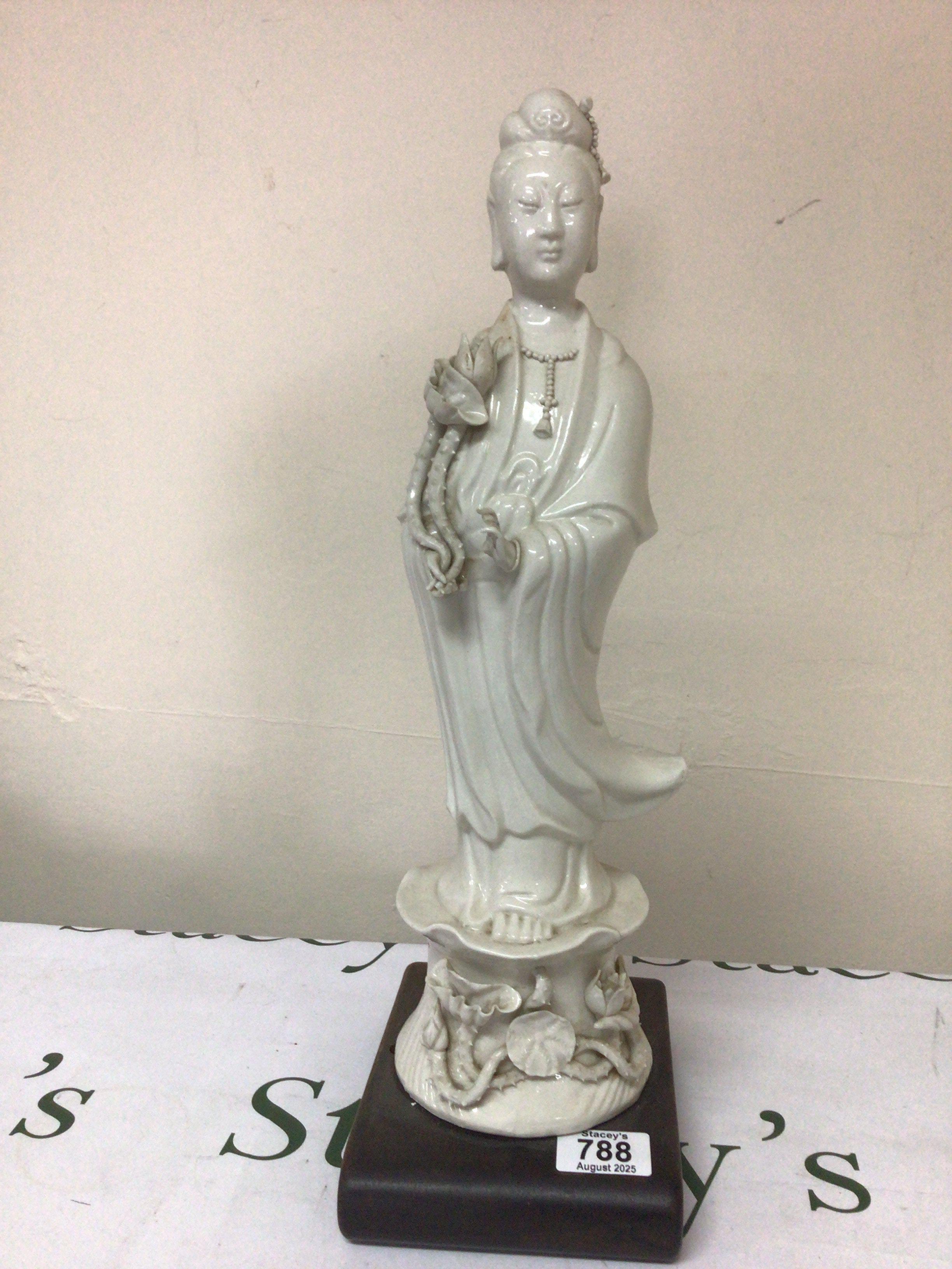 A Chinese porcelain figure Blanc De Chine figure of Guanyin stuck to a hardwood base some damage height 47cm