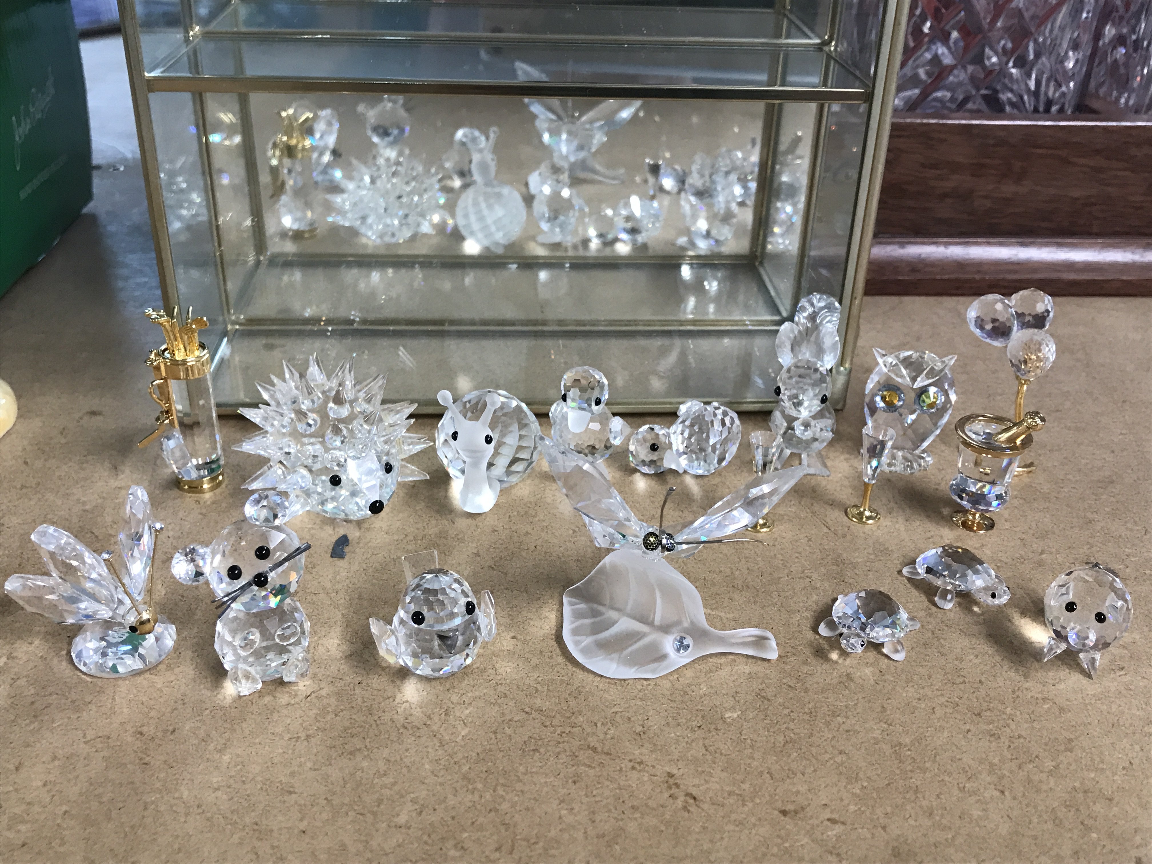 A collection of Swarovski figures and a display case. This lot cannot be posted- NO RESERVE