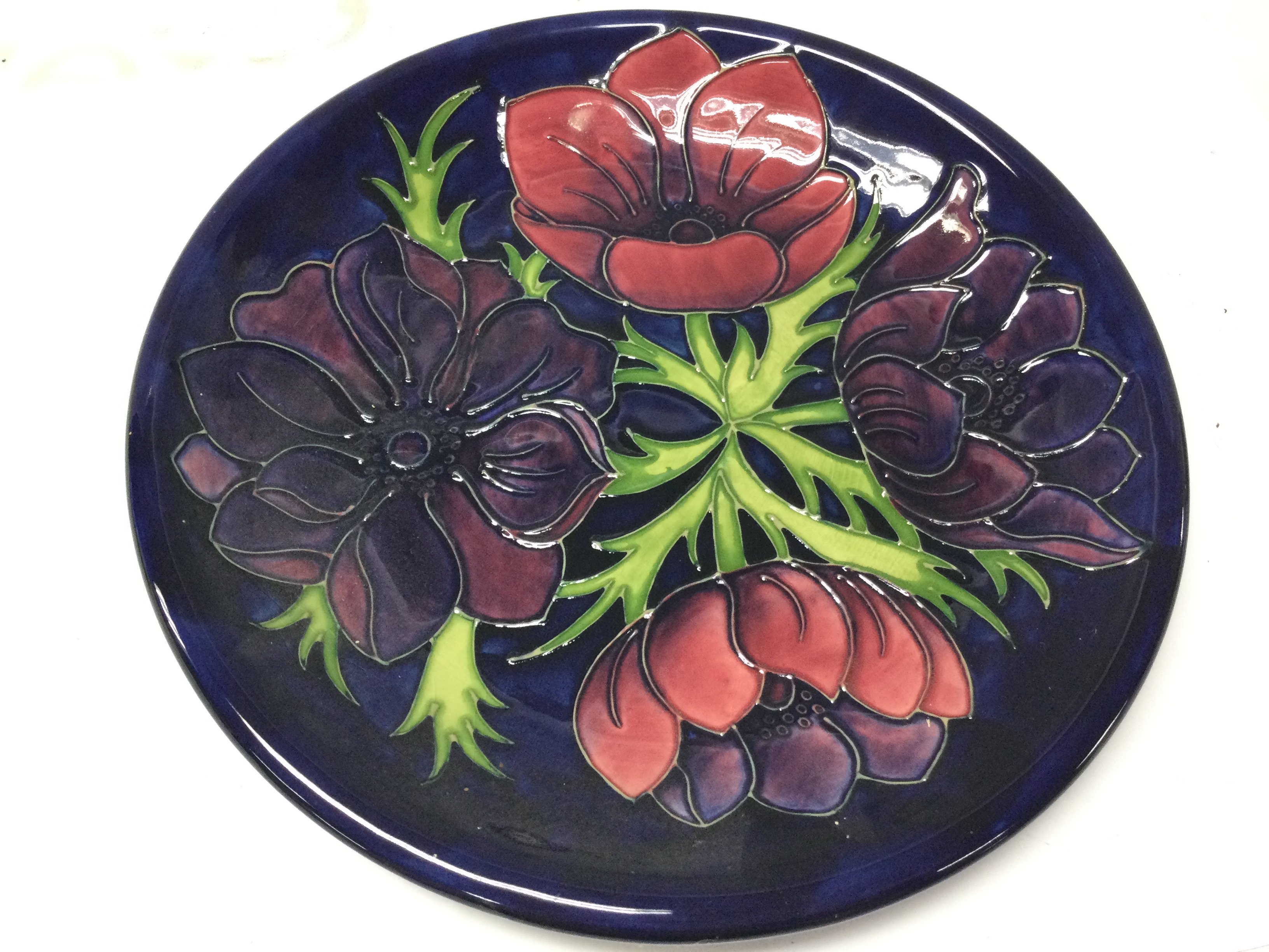 Moorcroft Blue ground Anemone dish, 25.5cm wide. No obvious damage or restoration. Crazing as seen. This lot cannot be posted