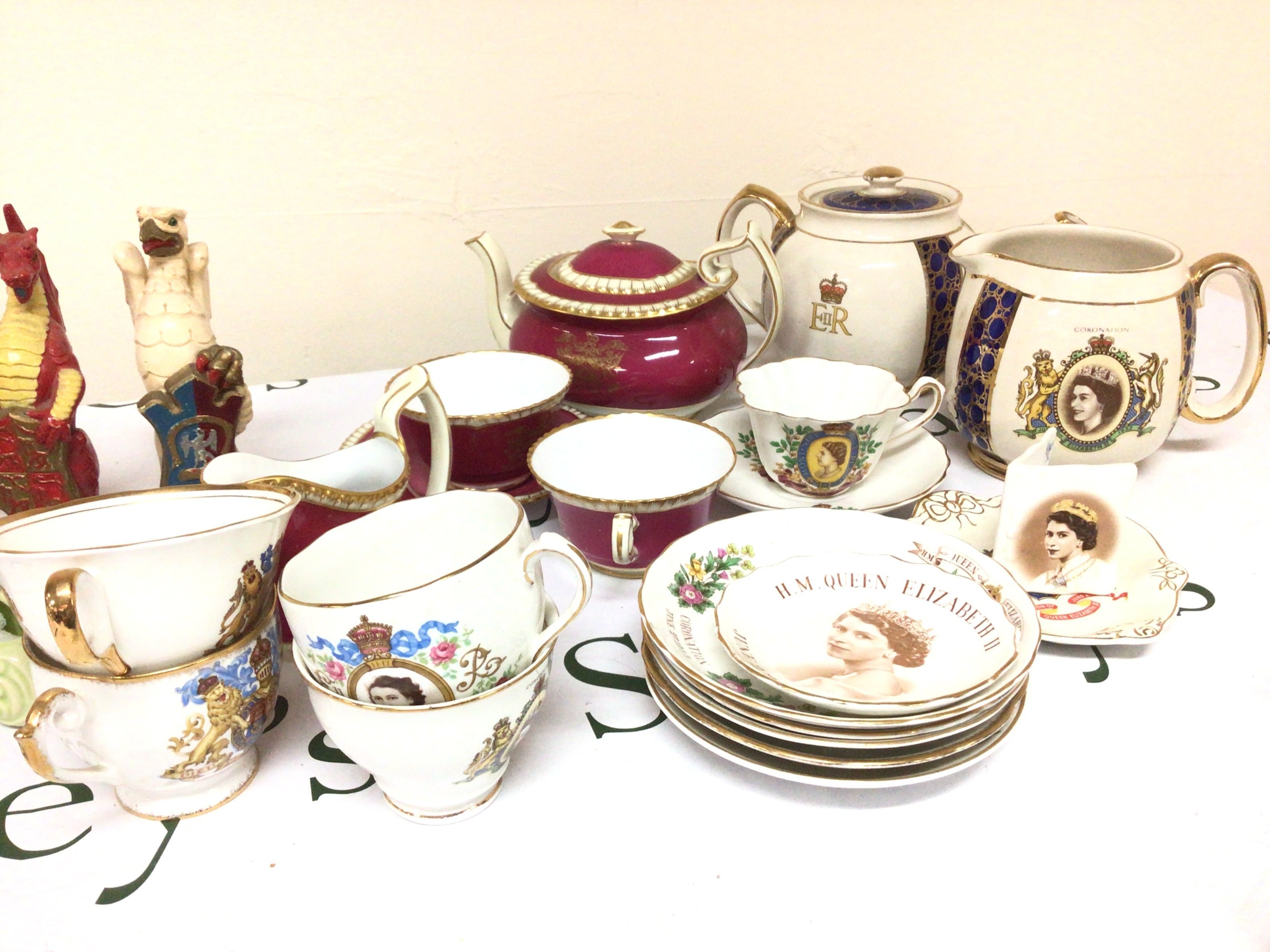 A collection of plaster Dragons and other mythology animals bearing coats of arms. A Spode tea set and a collection of Elizabeth II Royal commemorative coronation cups and saucers.- NO RESERVE