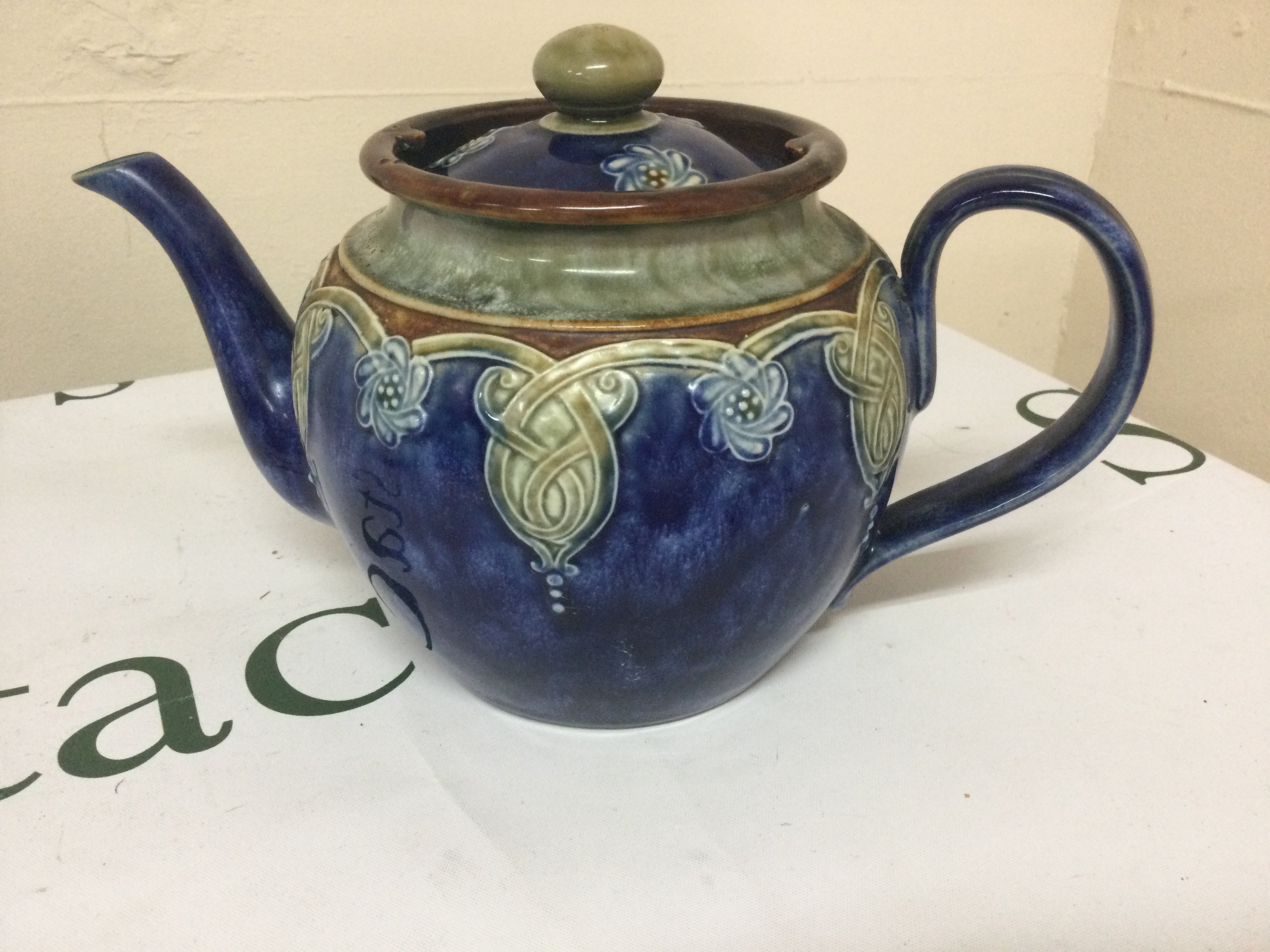A Doulton blue and green glazed tea pot.