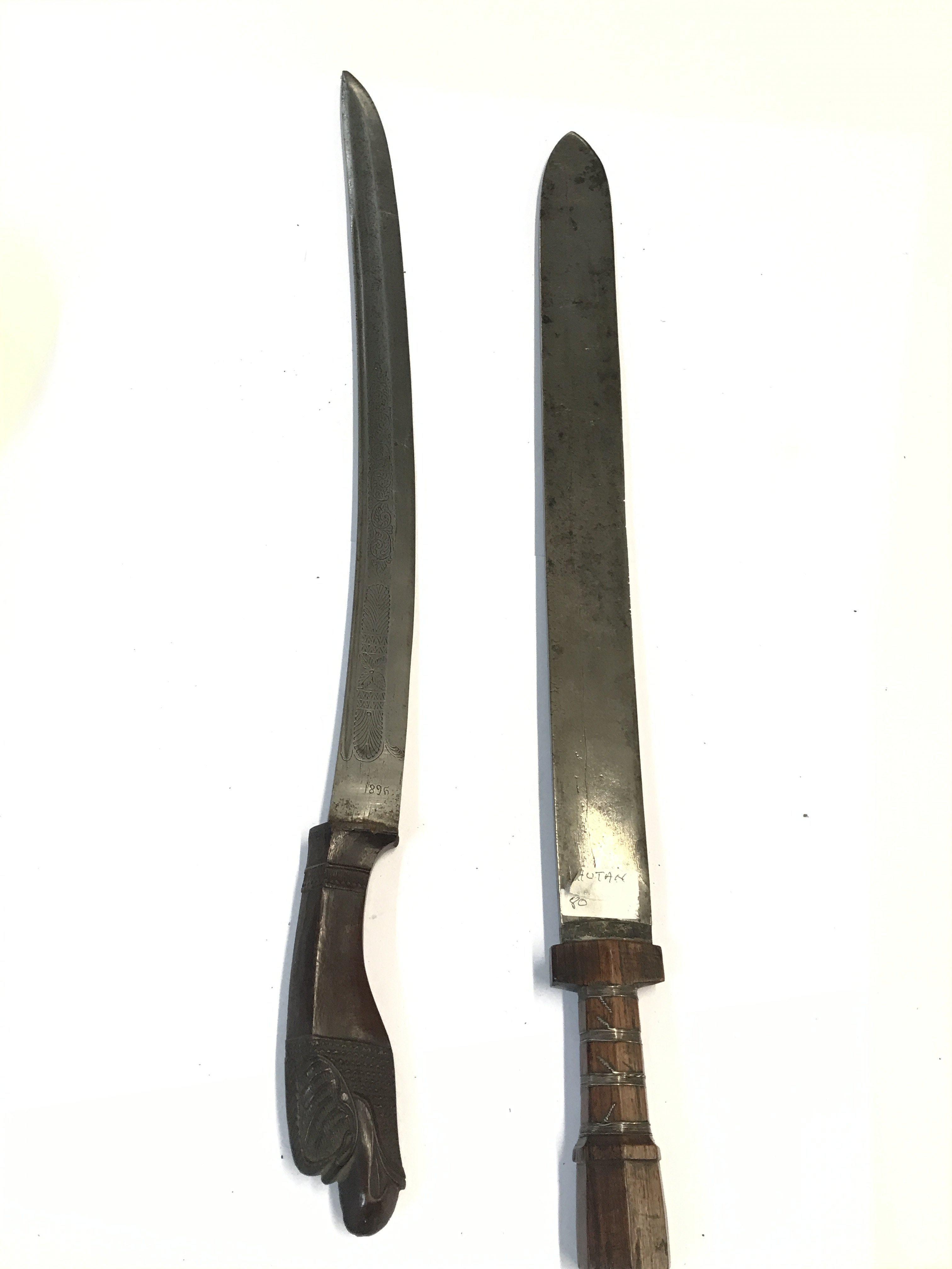 A Sumatran 19th century sword with carved hardwood grip the blade dated 1896 and a Bhutan sword with wired hardwood grip. (2)