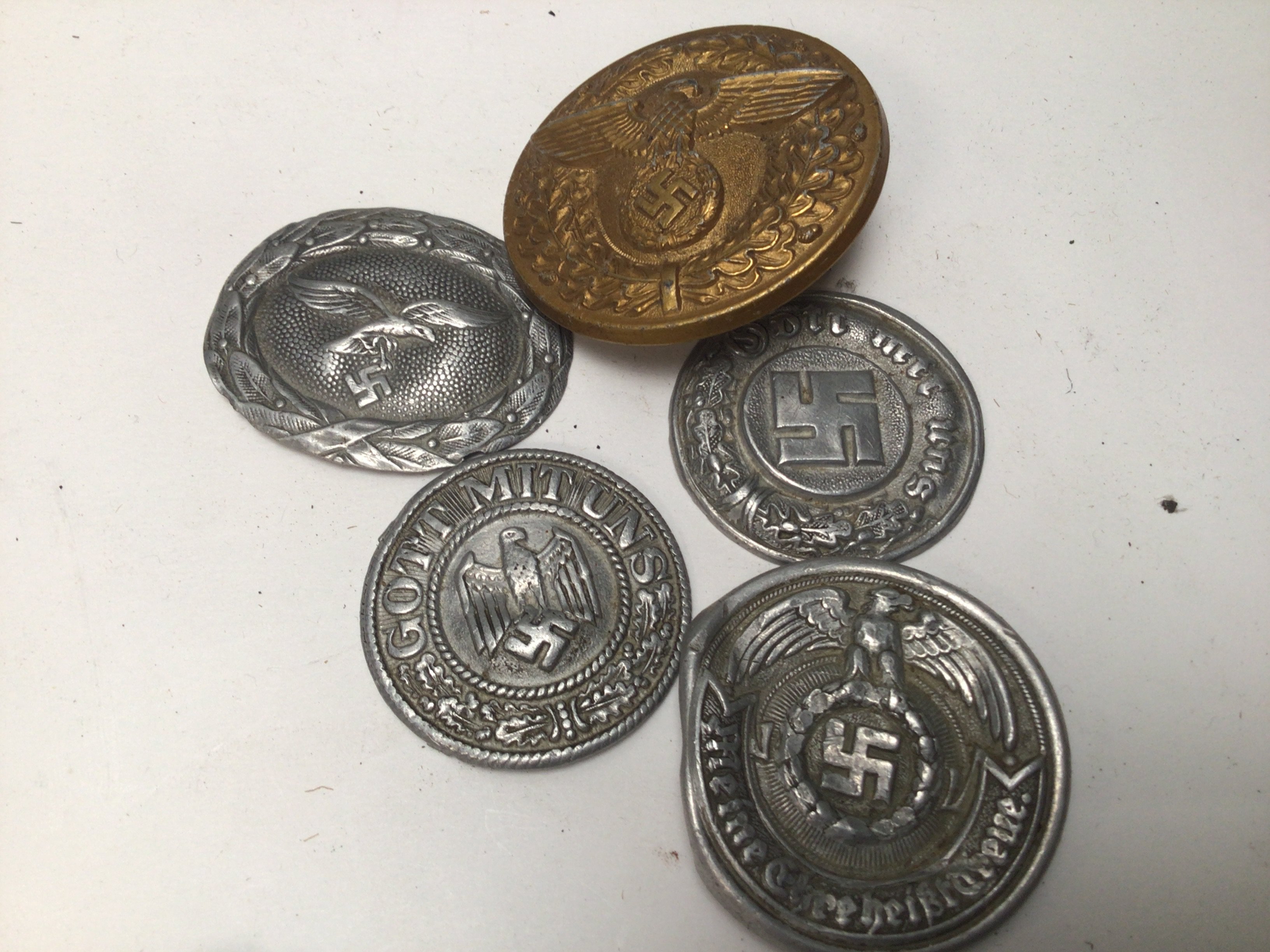 Four Aluminium pressed German Third Reich emblems including Luftwaffe and a gilt metal buckle the reverse with makers reference marks.