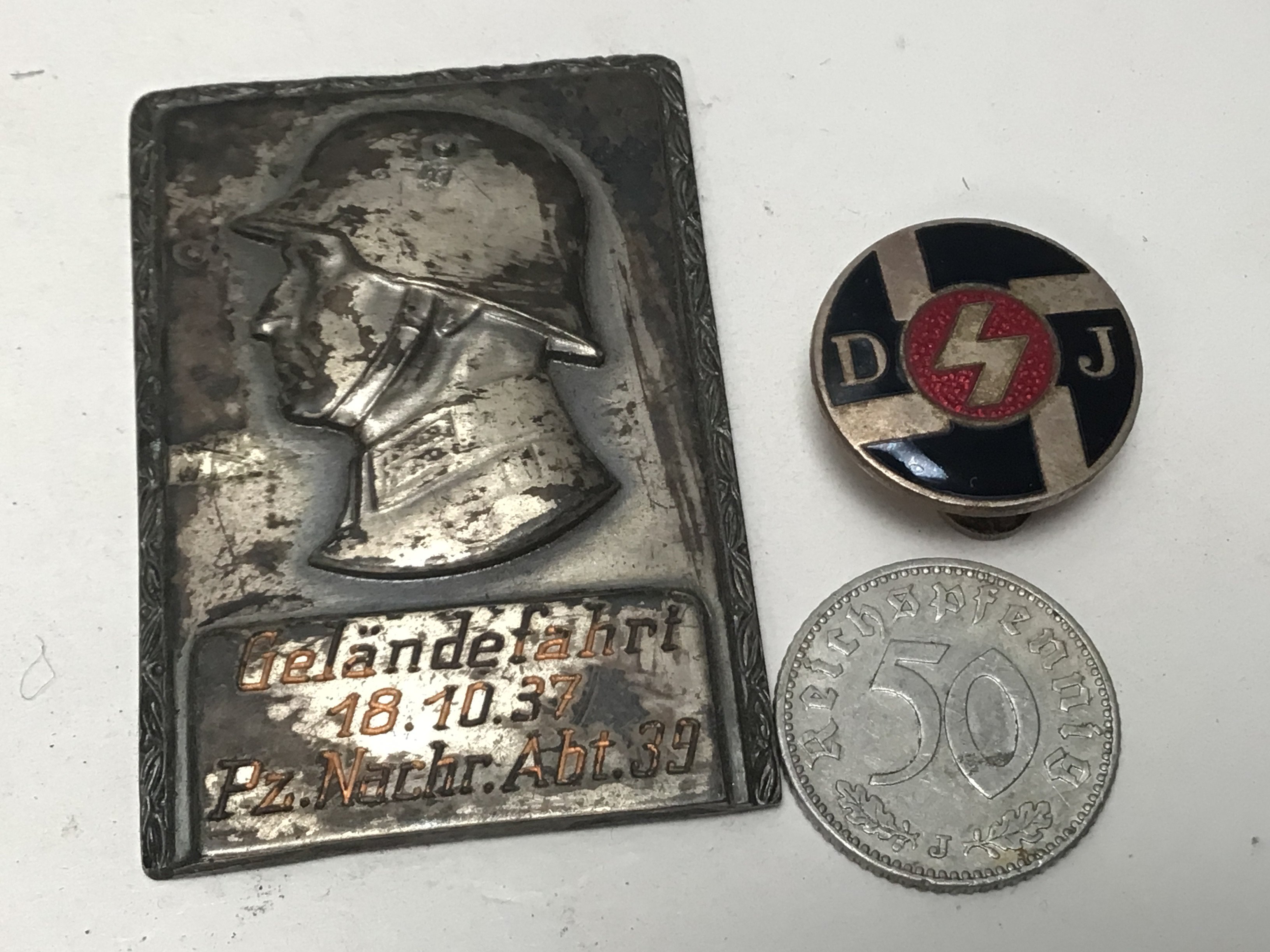 A Rare Early Hitler Movement badge enamel with D J initials a small plaque dated 18.10.37 and a coin (3)