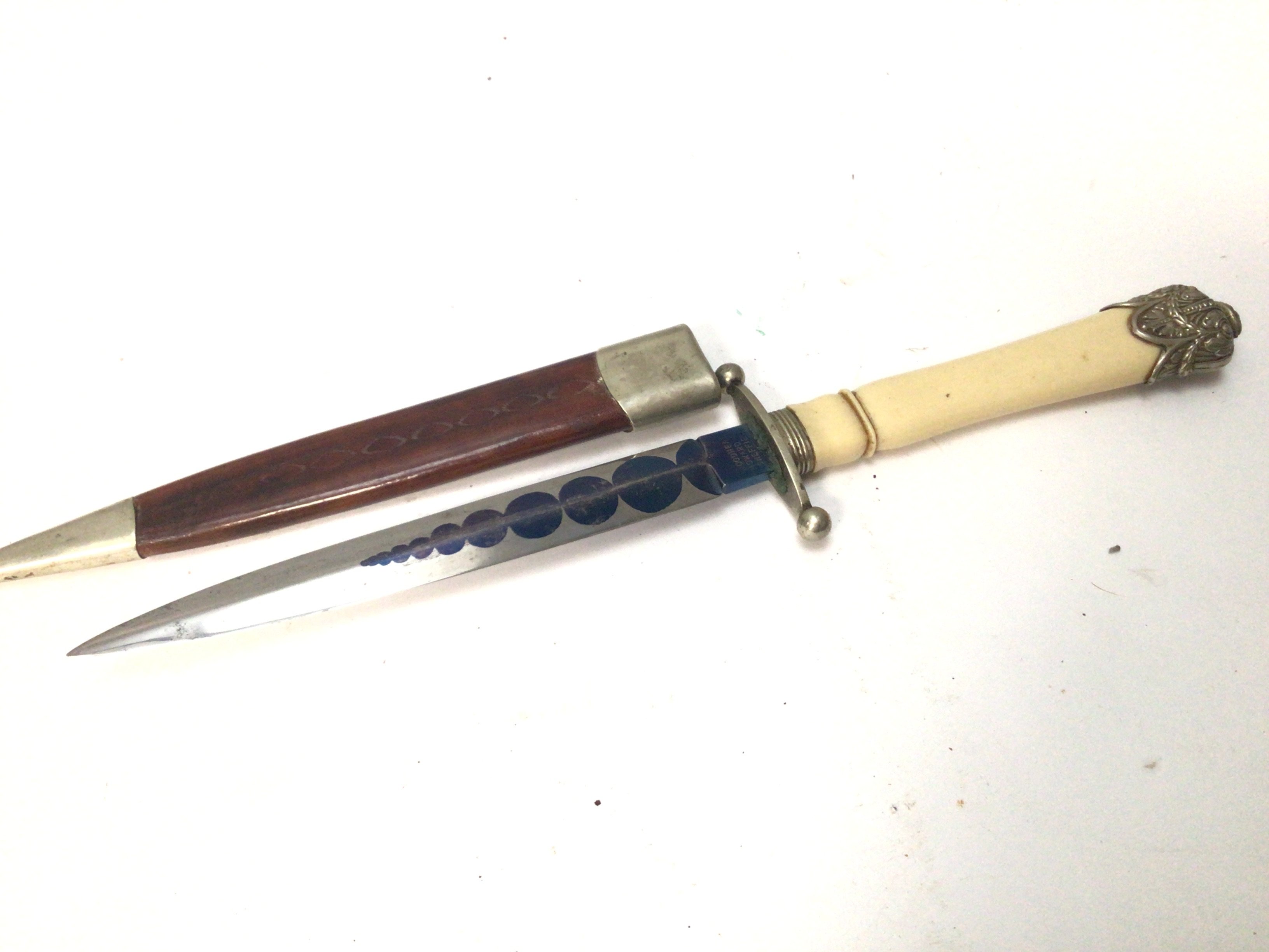 An unusual Presentation dagger the blade with a graduating blued circle pattern maker woodhead Sheffield. With a leather scabbard length 31cm