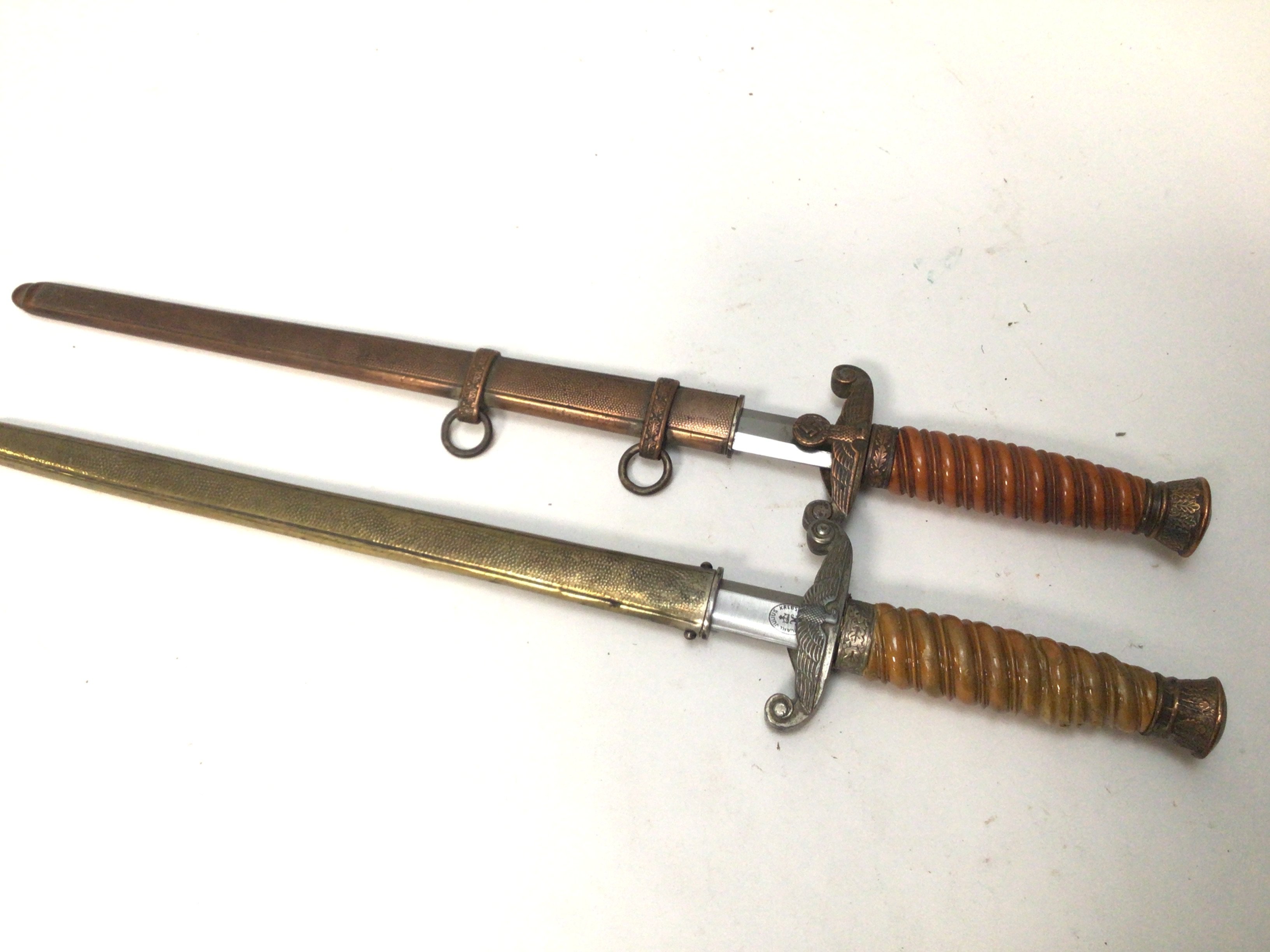Two German II world war Third Reich military officers presentation daggers oth with makers names to the blades one with a copper finish on with damage (2)