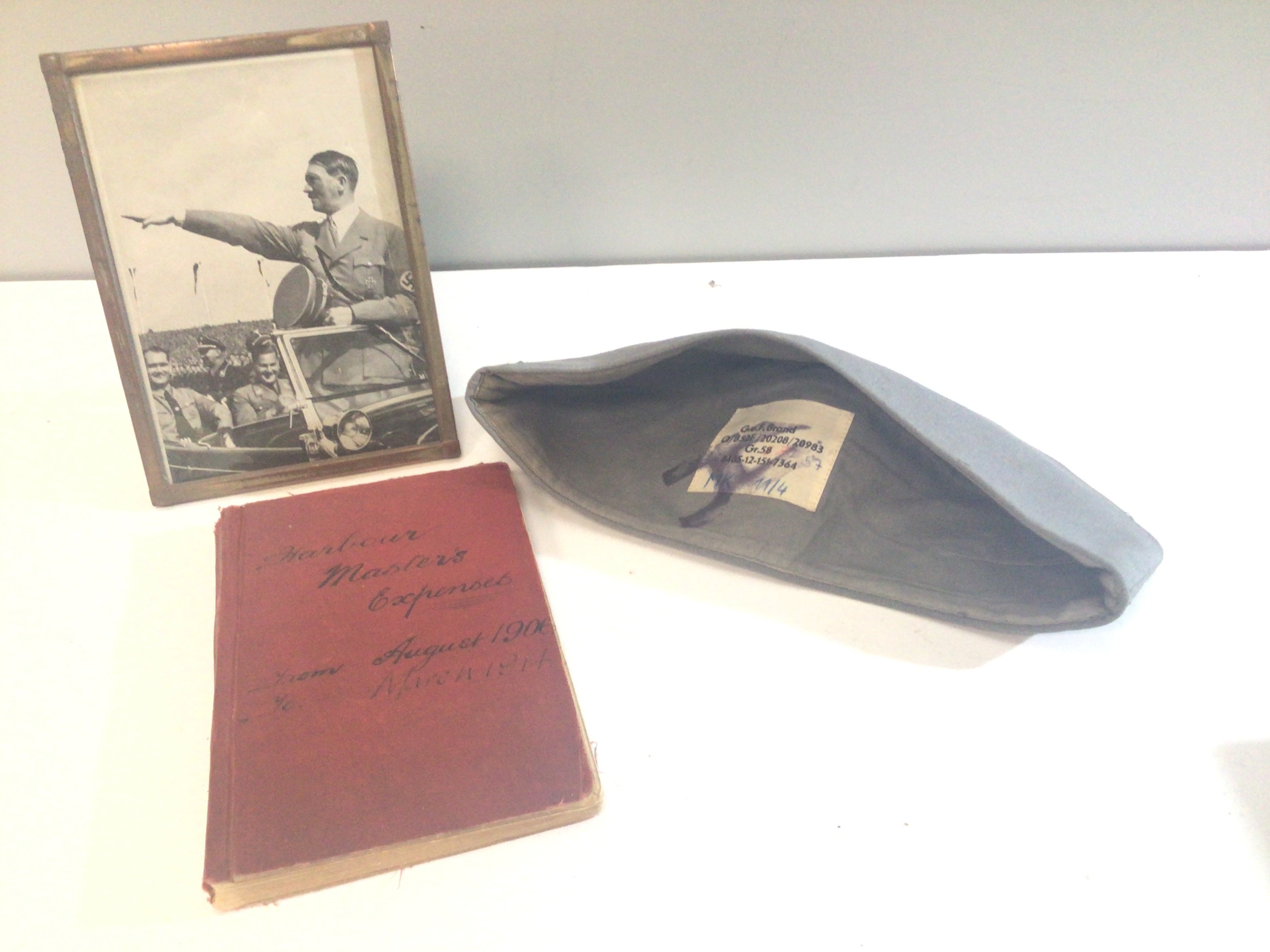 A German Third Reich Luftwaffe cloth cap a photograph of Adolf Hitler and a hand written Harbour Masters Expenses book 1906-1914.