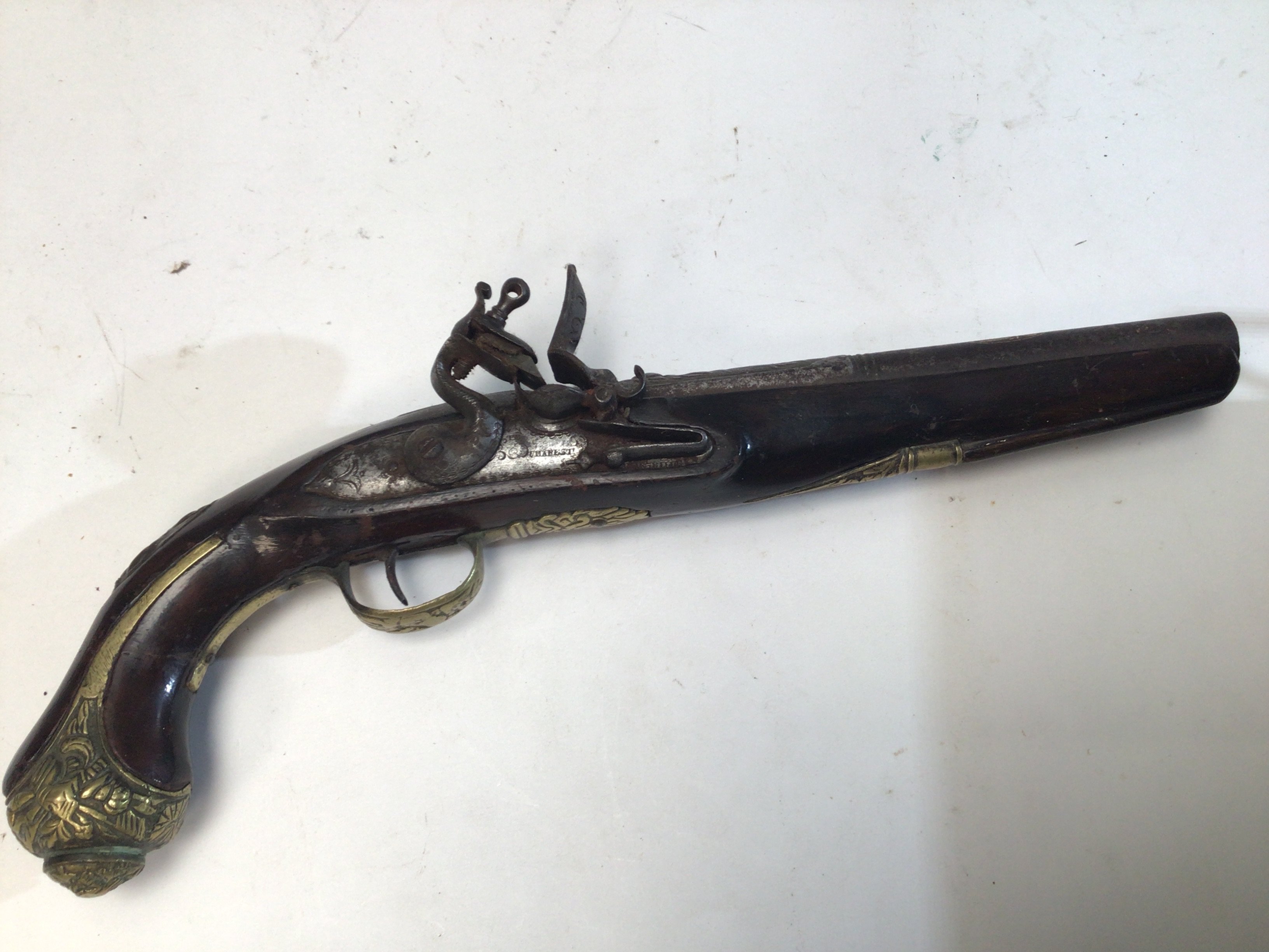 A French 18th century flintlock lock pistol maker Dumarest with brass mounts and ornamented cast barrel with applied gold decoration.