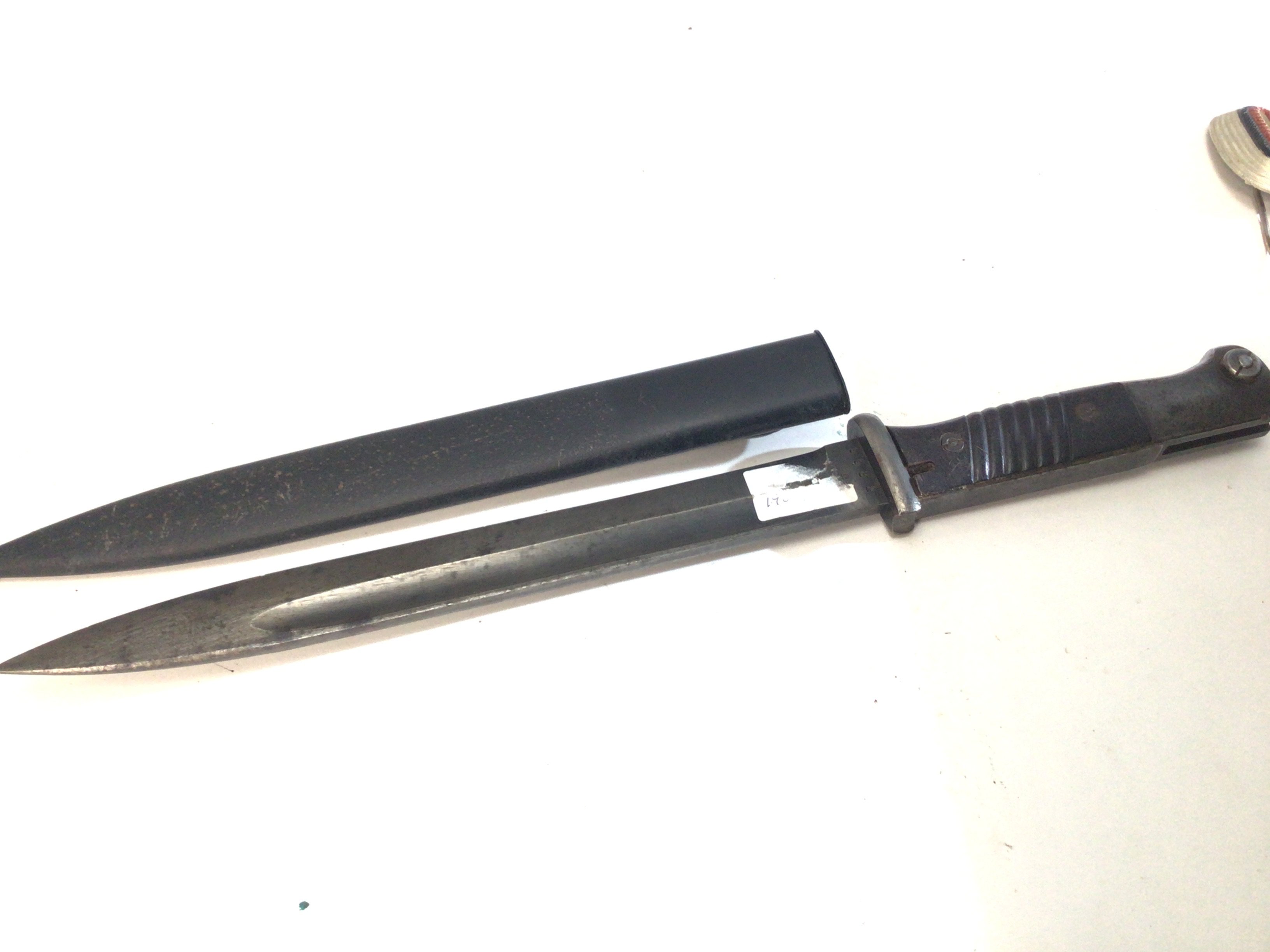 A German Third Reich K98 bayonet the blade stamped 43 fze also numbered 5582 the steel scabbed stamped and dated J.Sch1938.