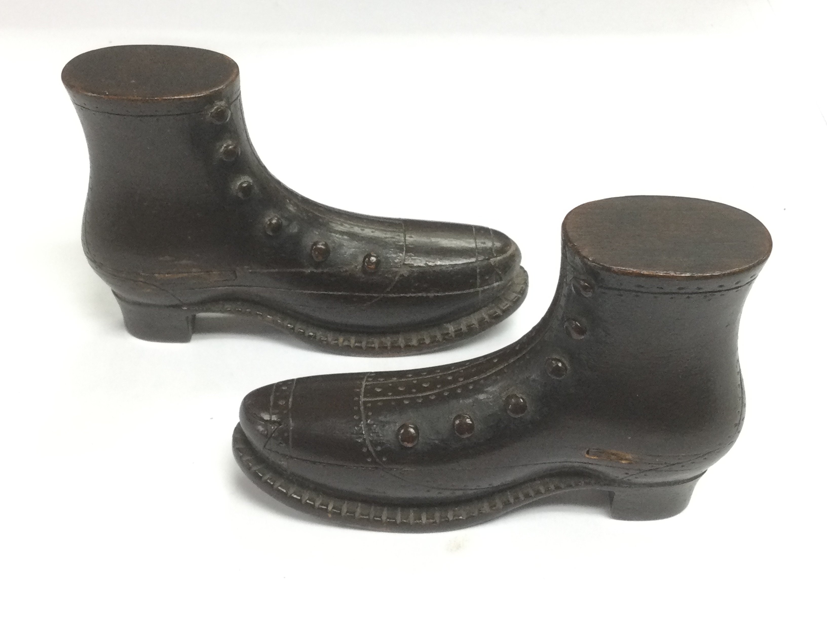 A pair of POW carved puzzle boxes in the form of boots, approx length 10cm. Shipping category A.