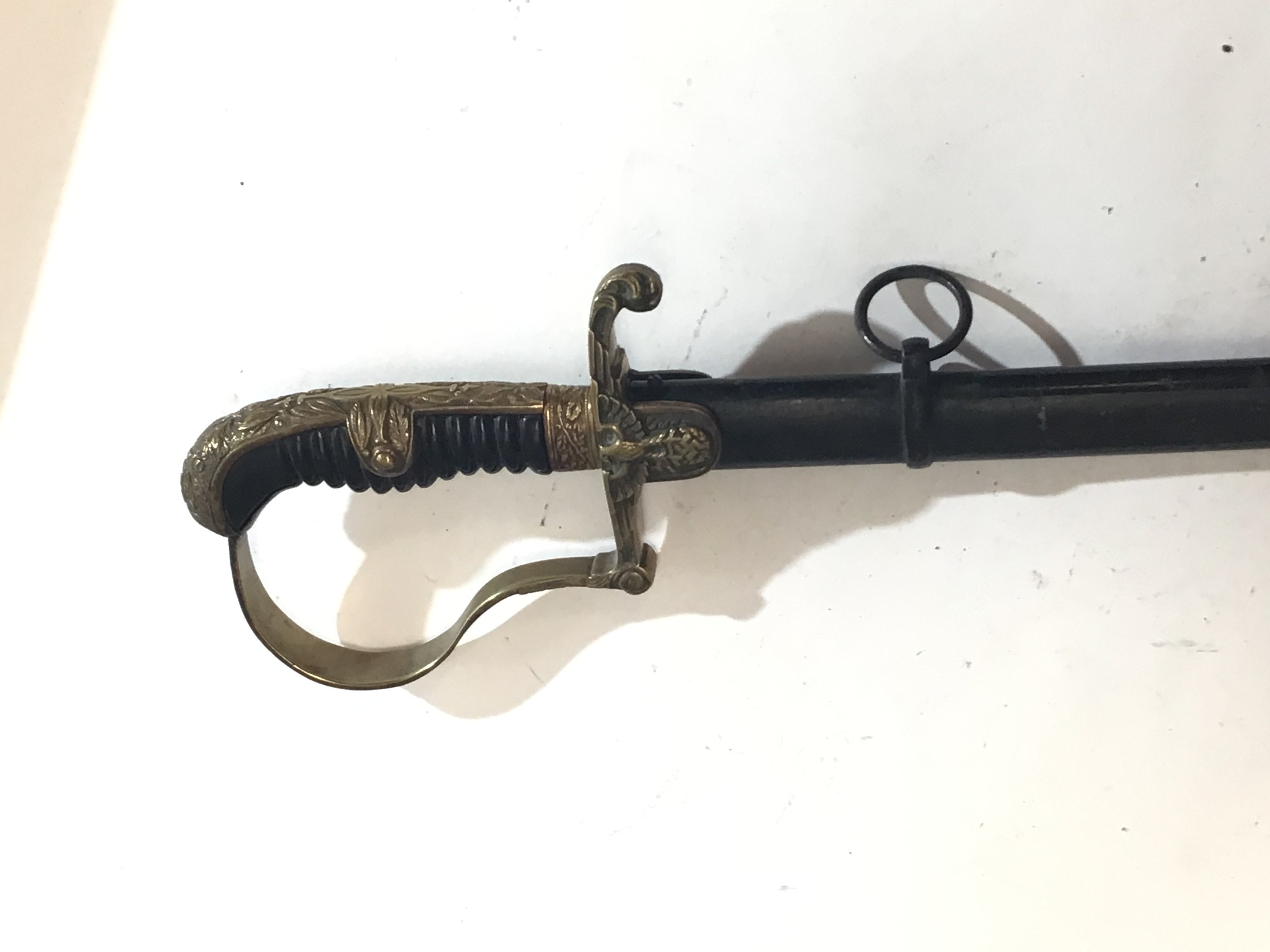 A German Third Reich officers Military dress sword most likely by WKC makers mark on blade slightly protruded a good example with dove head patterned brass lager with swastika black scabbard clean blade.