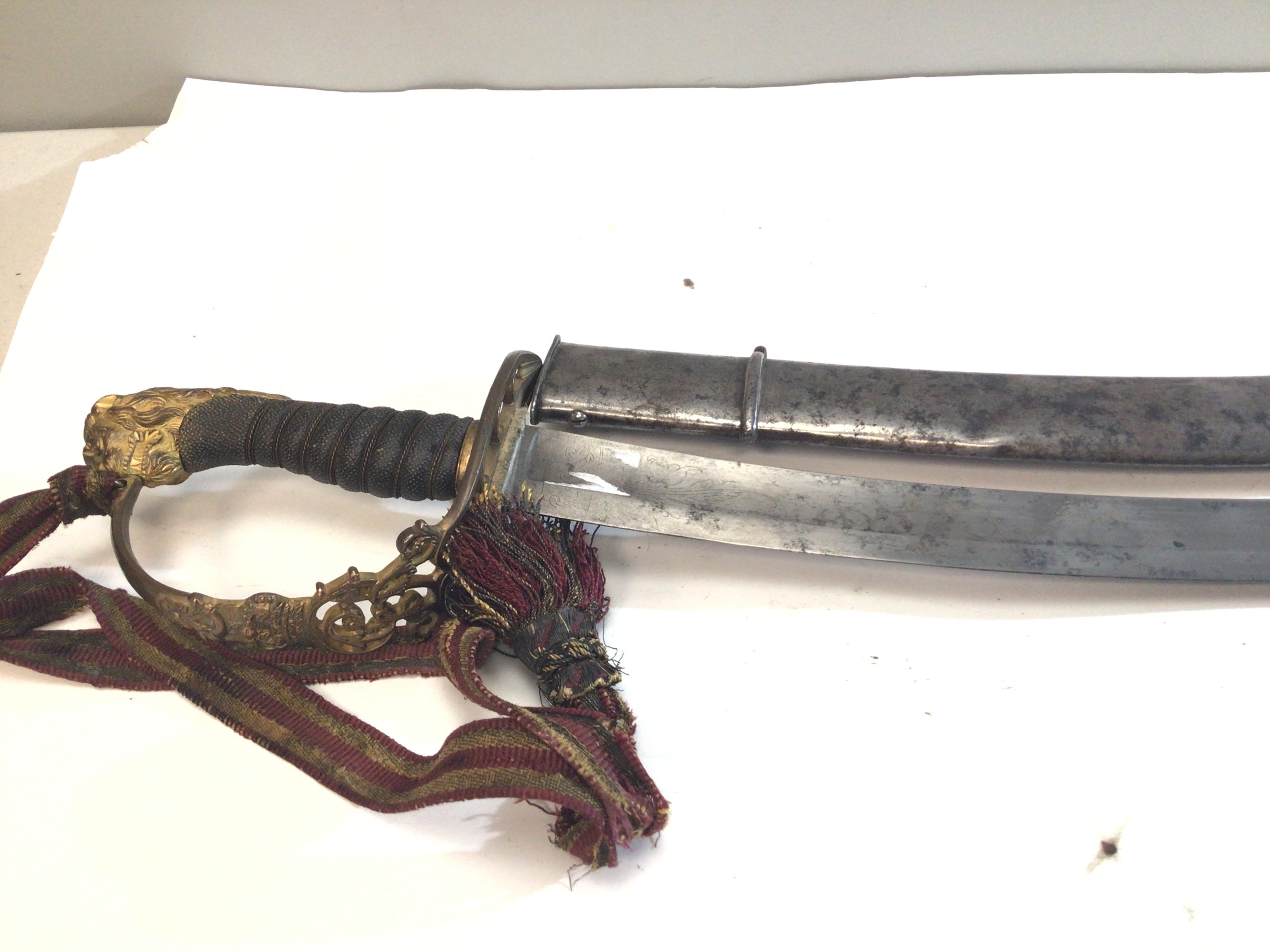 A Rare British Military George III 1803 Sabre. This rare sword with a wired Shagreen grip lion head pommel and with the cypher of George III the curved blade with makers mark to the blade Webe Manufactures 57 Picedills (Piccadilly) London also with the inscriptions Warranted. These swords where bought by officers and not standard Military issue. Used by Infantry flank officers. This example with a steel scabbed length 88cm