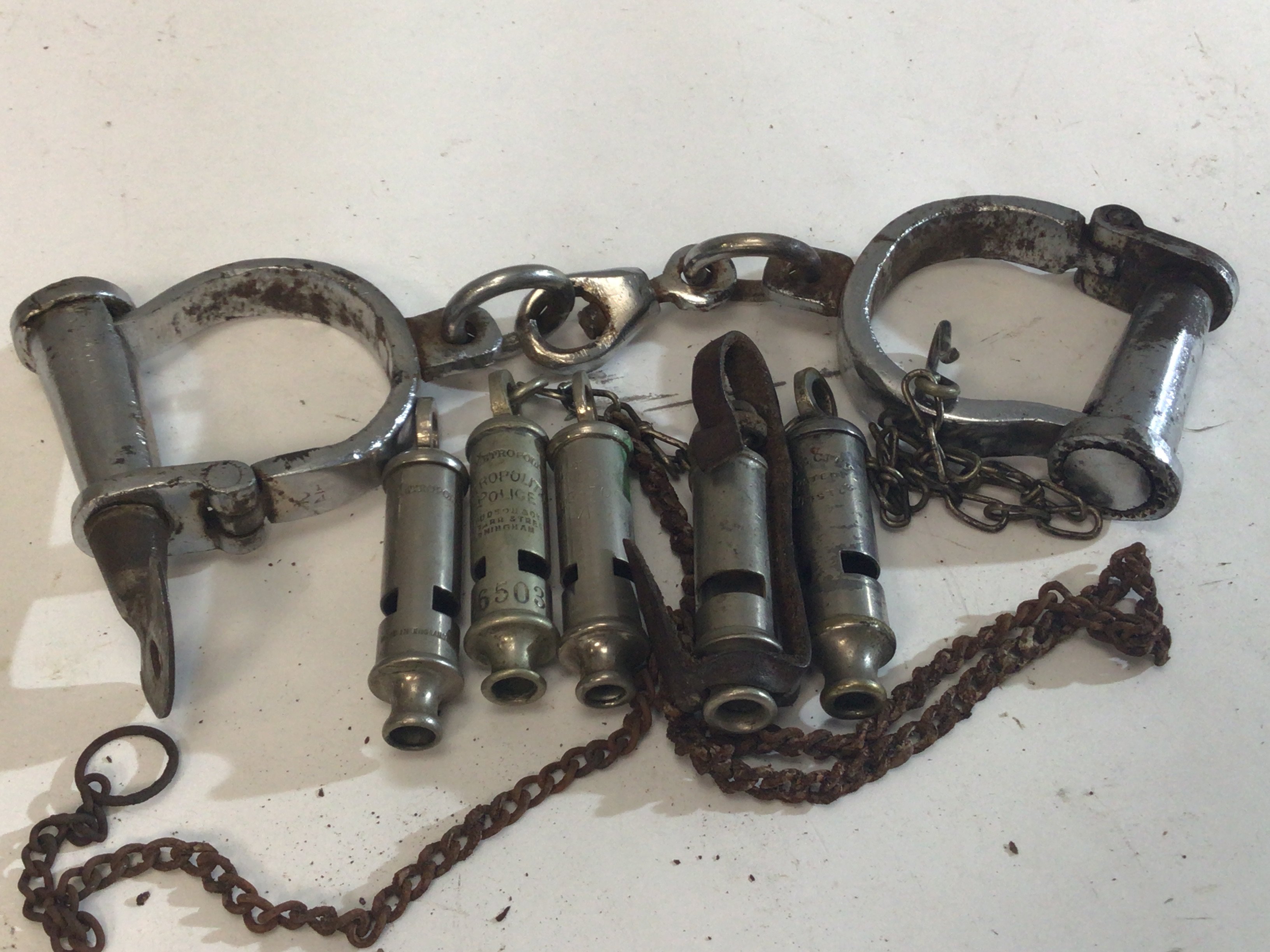 A Pair of Vintage handcuffs five vintage Whistles including Metropolitan Police and Military and a Pewter RAF tankard.