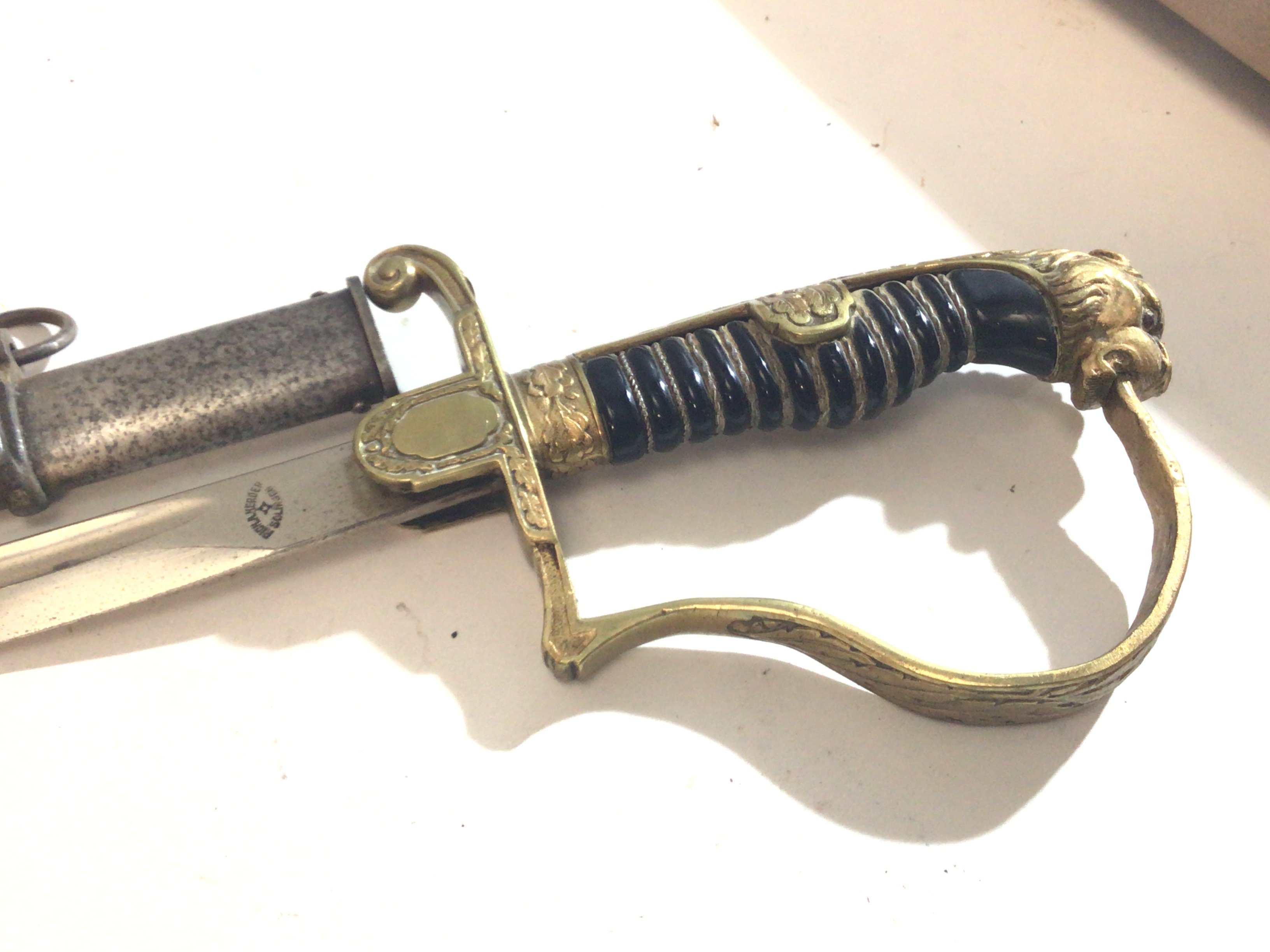 A German Third Reich officers sword with brass gilded Metal Finish with lions head pommel the blade stamped Rich A Herder Solingen.