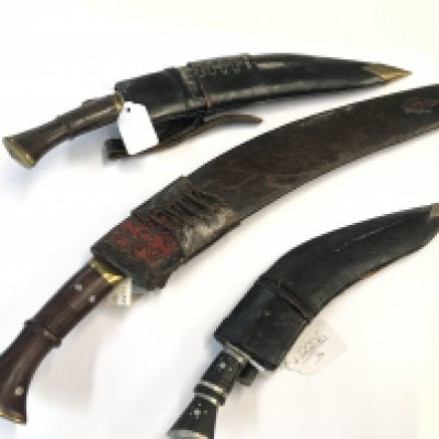 Three Early 20th Century Kukri Knifes The Traditional Nepalese knife. With brass set wood and horn handles including a smaller example (3)
