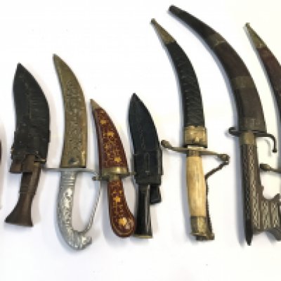 A collection of Middle Eastern and Indian daggers including a Sikh Kirpan dagger small Nepalis kukri knifes and others