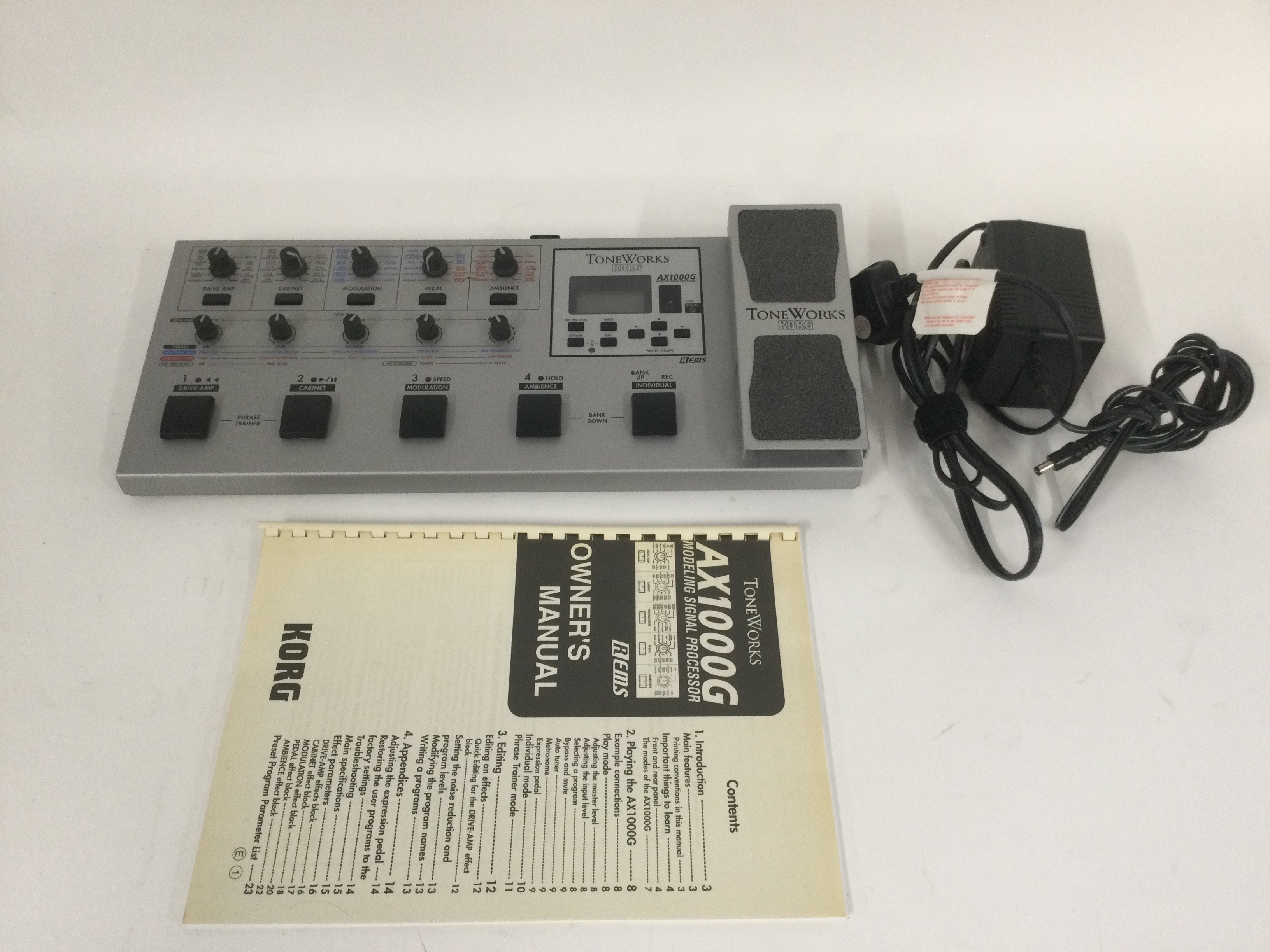 A Korg Toneworks AX1000G multi effects pedal with user manual and power lead.