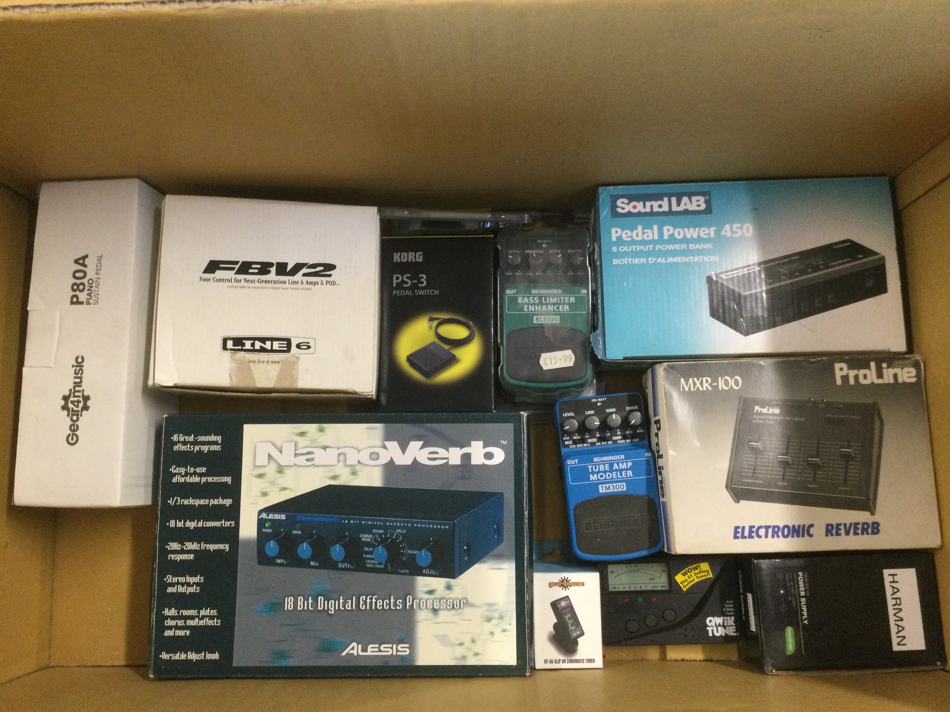 A box of effects pedals comprising an Alesis Nanoverb, various Behringer pedals etc.