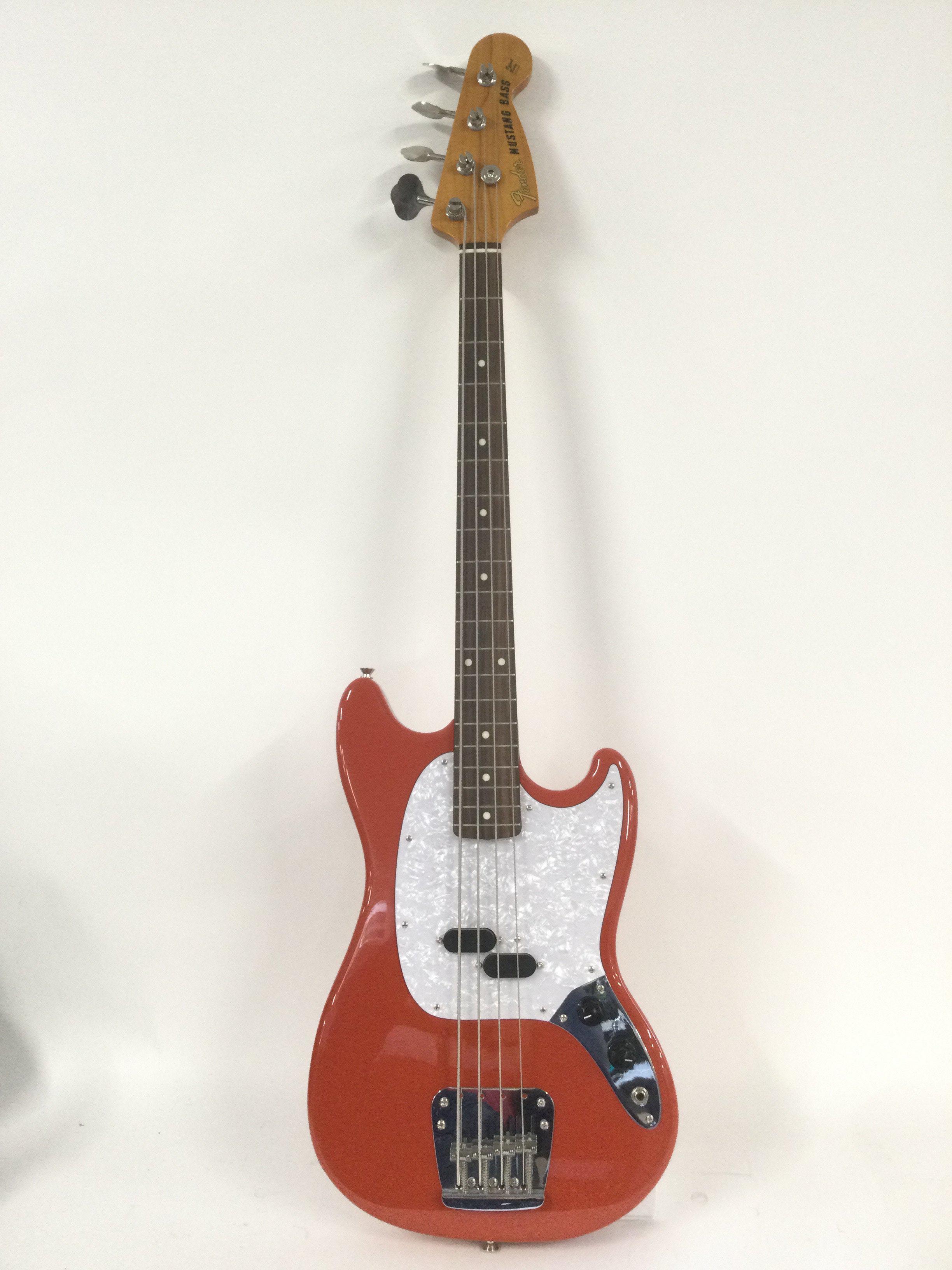 A Japanese Fender Mustang bass in fiesta red with a white pearloid scratchplate. Comes with a soft carry case. Not fitted.