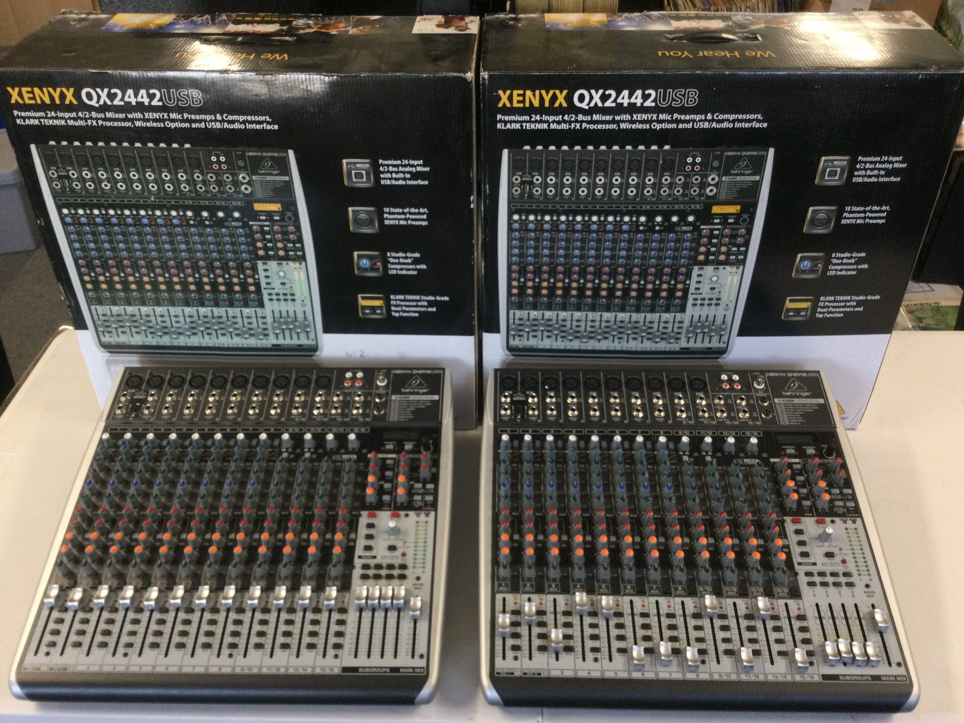 Two boxed Behringer Xenyx QX2442USB 24 input mixers.