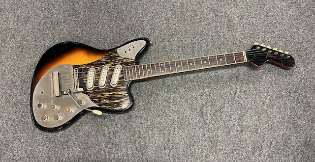 A 1964 Framus Strato De Luxe Electric Guitar. 3 pickup with all original parts. Condition good overall with some edge marking and playwear to the body. US 1 cent coins glued to the tops of each control. Comes with non original gig bag.