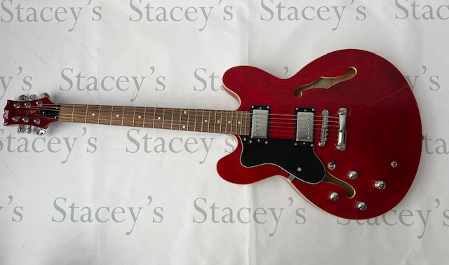 A Tanglewood TH502 Semi Acoustic Electric Guitar in Transparent Cherry Red. In very good + condition with little evidence of playwear. Little or no fret-wear, no marking and no tarnishing to brightwork.