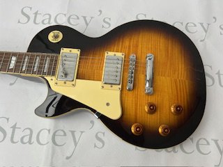 An Epiphone by Gibson Les Paul Standard type left handed electric guitar in Tobacco Sunburst with flame maple top. All original with light play-wear and light marking. Overall very good condition, Comes with non original hard case  Click Here to Register to bid