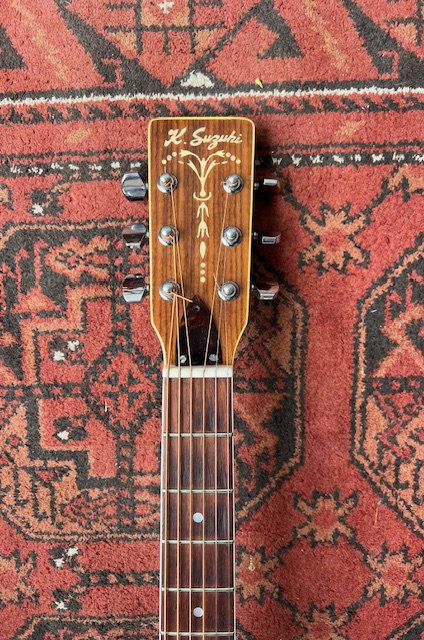 A 1980's Kiso Suzuki KW150 Dreadnought guitar in good condition with playwear to the top. Mother of pearl binding and three piece back.