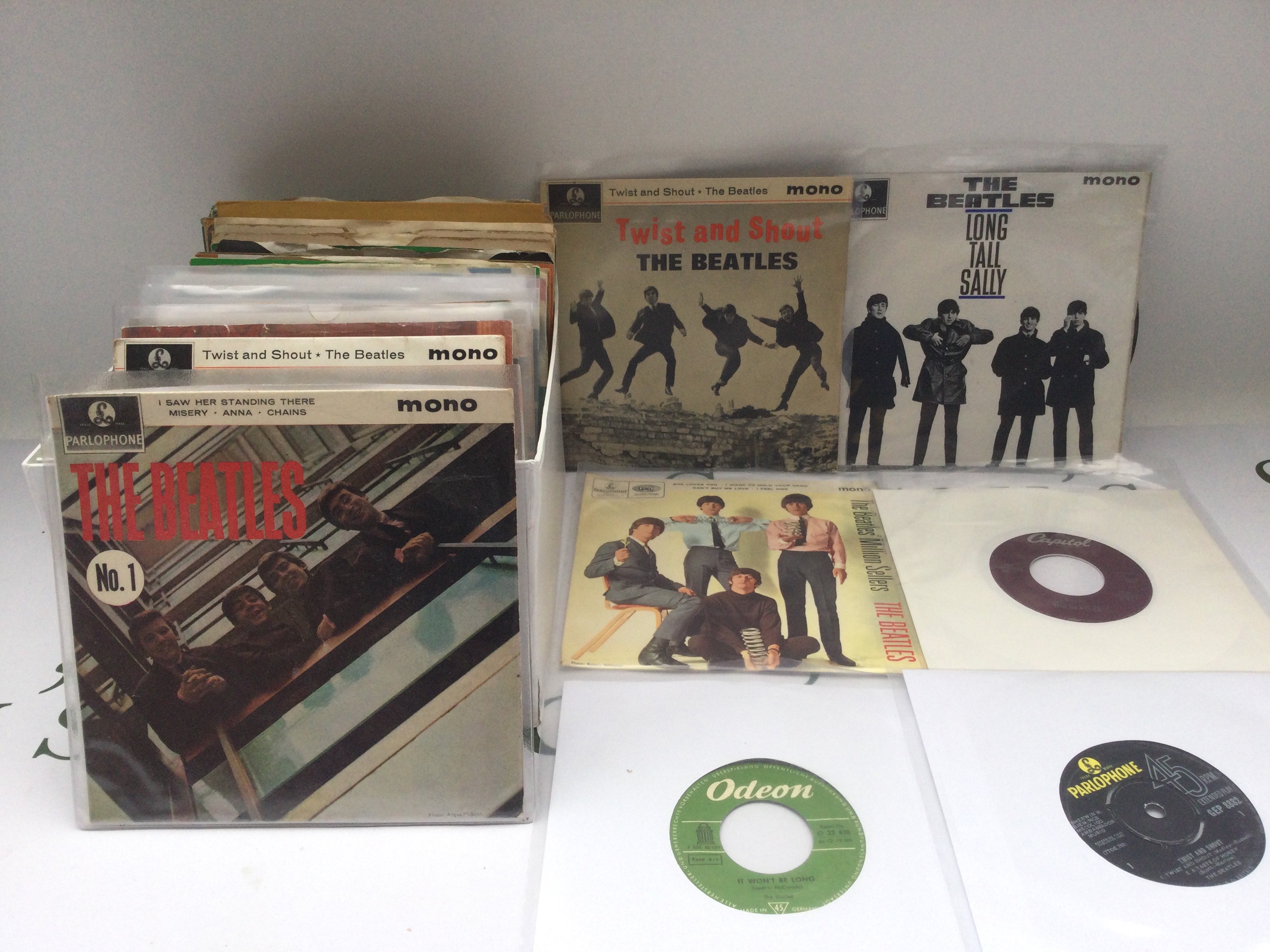 A collection of Beatles 7" singles and EPs including a Capitol pressing of 'Help!' and 'Money' / 'It Won't Be Long' on Odeon.