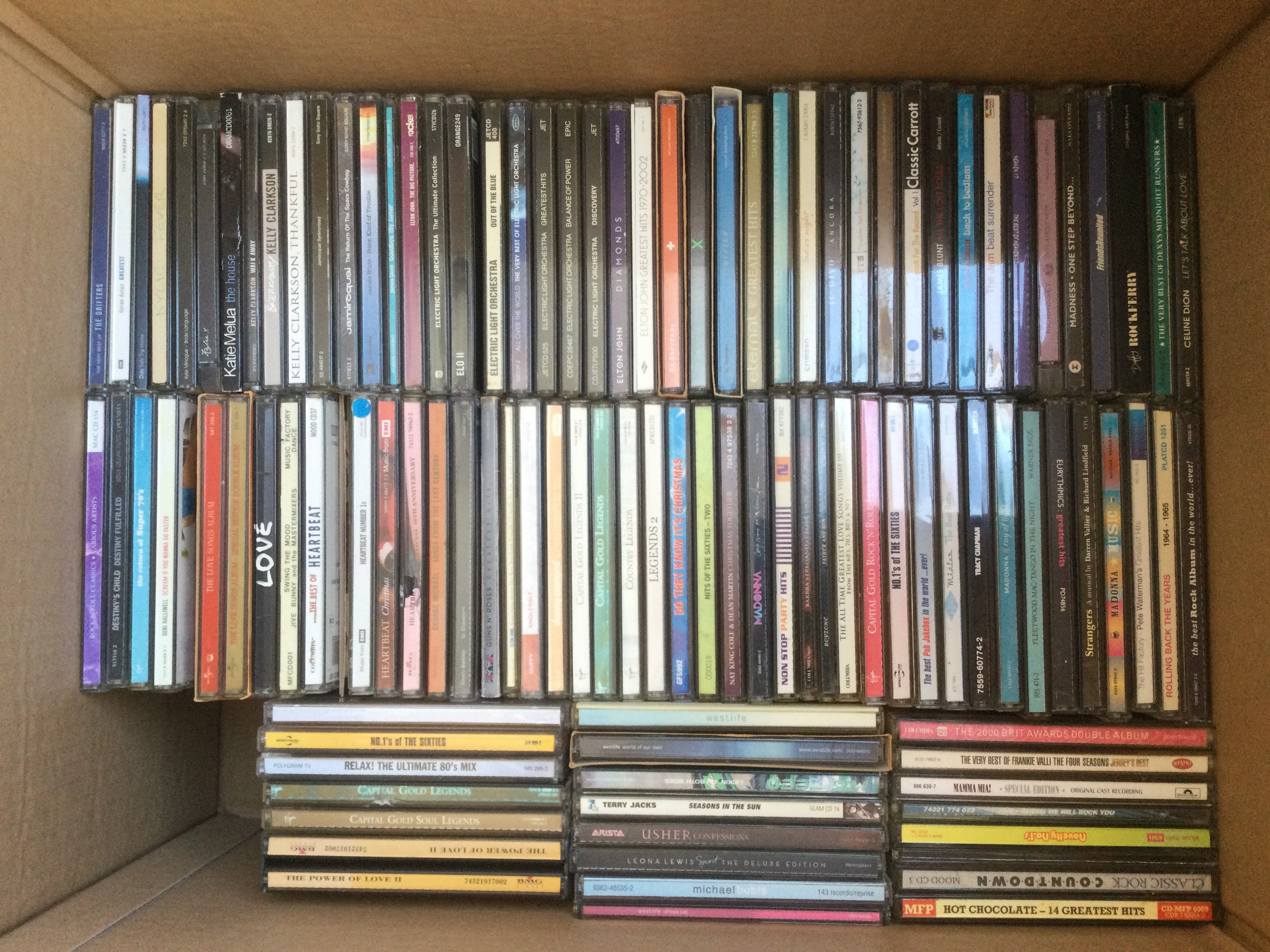 Two boxes of CDs by various artists including Queen, Guns n Roses, Paul McCartney and many more.