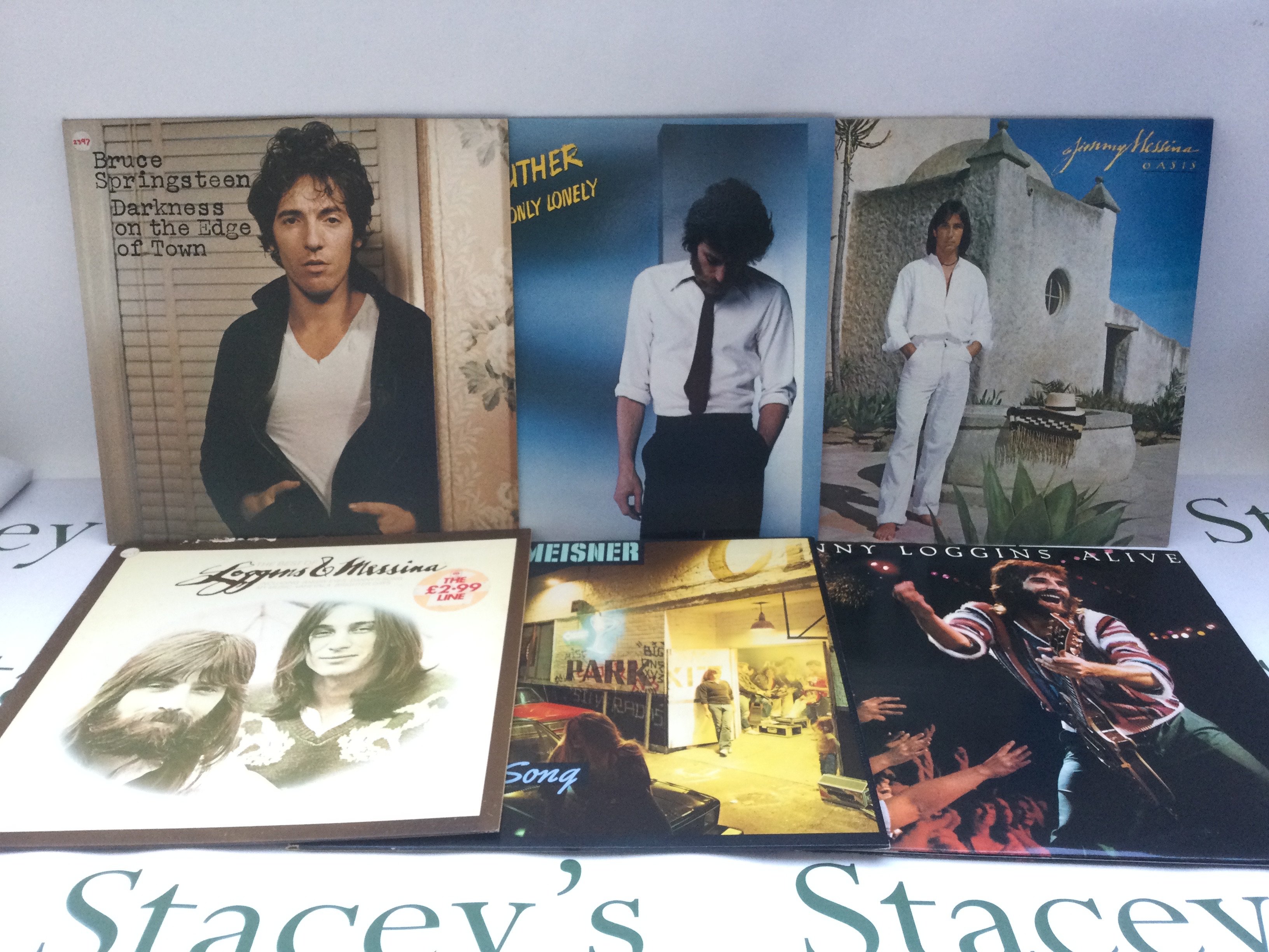 Two bags containing 22 promo copy LPs and 12" singles by various artists including Bruce Springsteen, Loggins & Messina, Carole King and others.