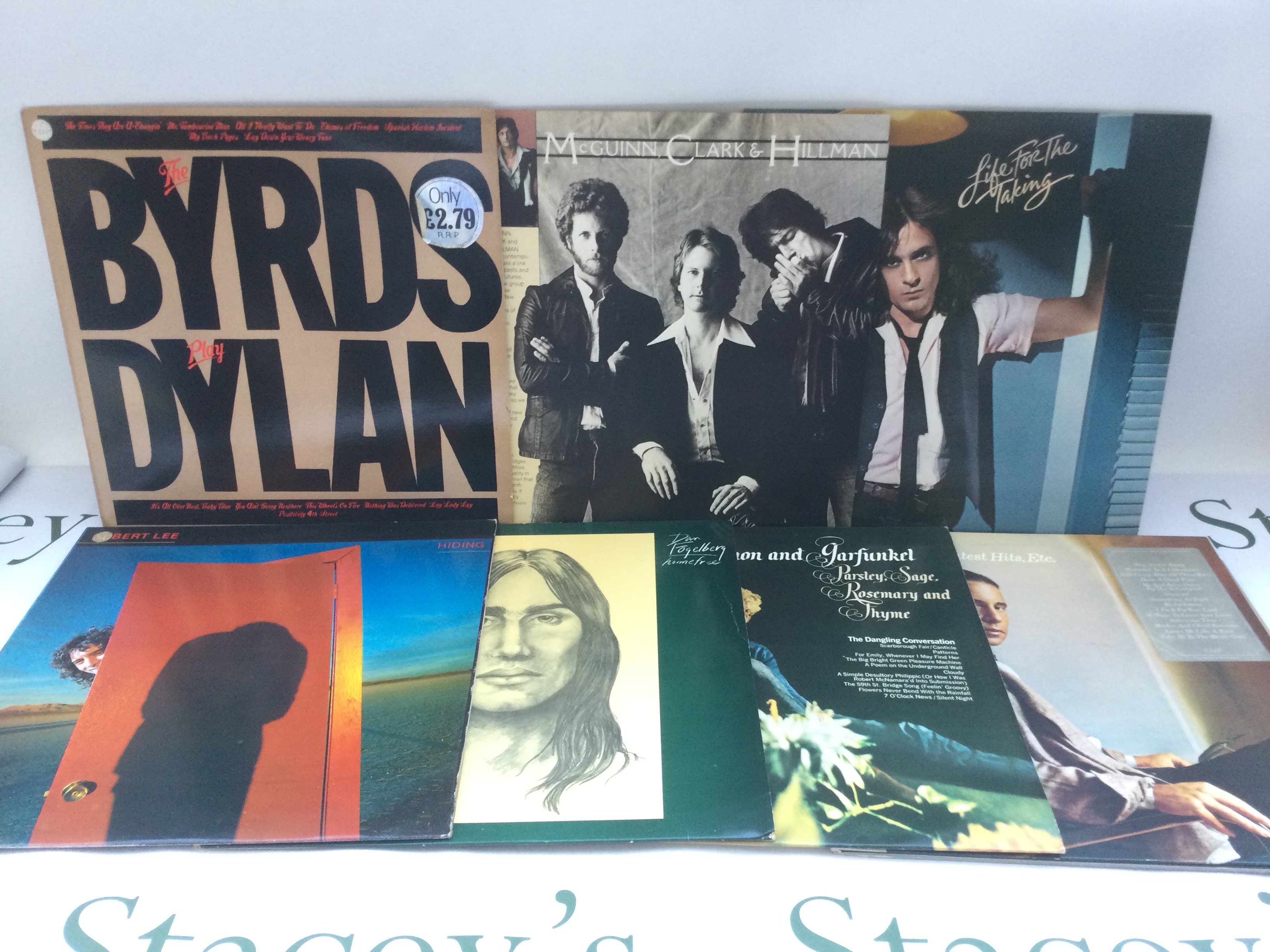 Two bags containing 23 promo copy LPs and 12" singles by various artists including The Byrds, Albert Lee, Michael Schenker Group and others.