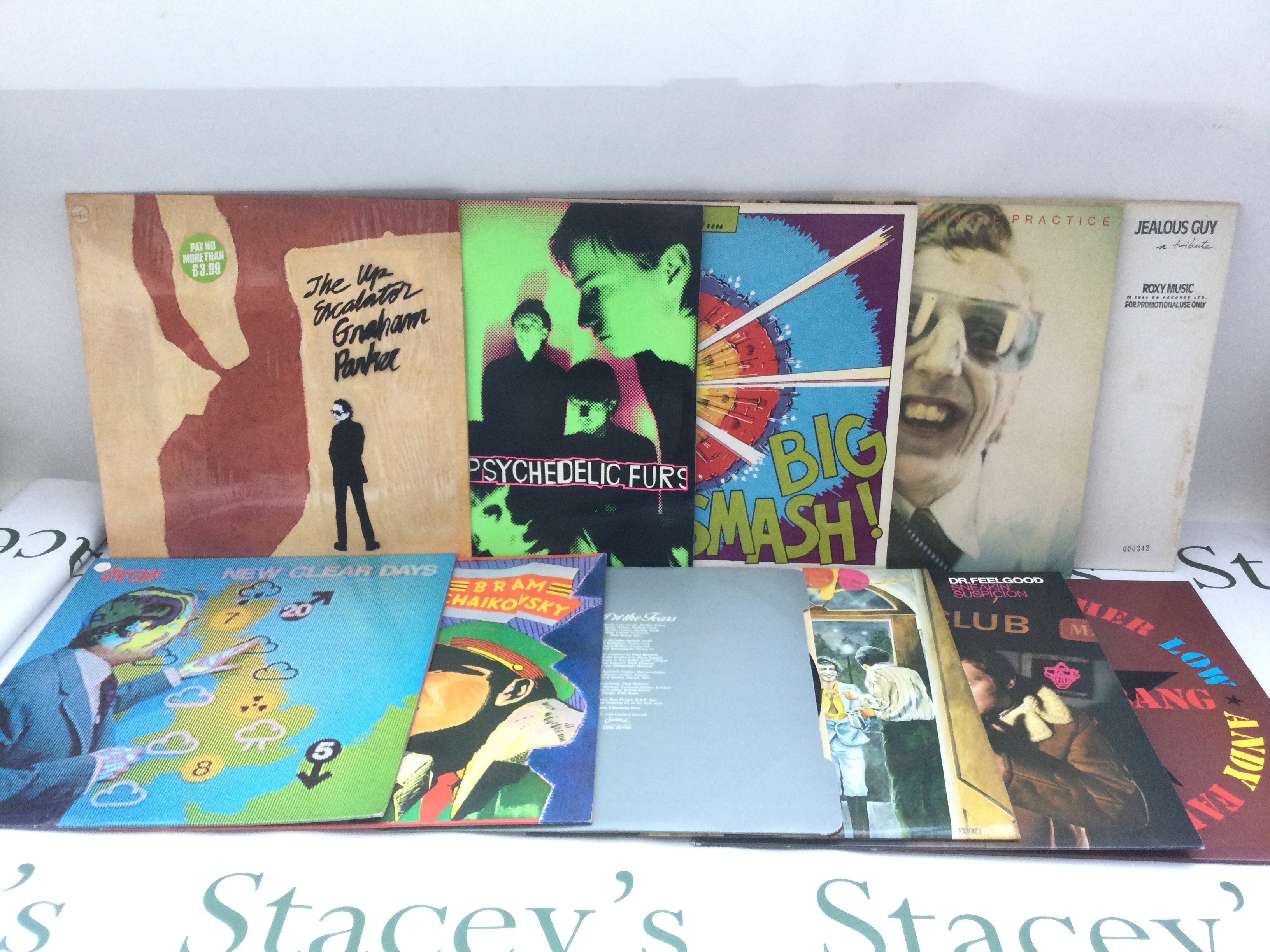 Two bags containing 20 rock and new wave LPs and 12" singles by various artists including Dr Feelgood, Roxy Music, Be Bop Deluxe and others. Includes a Roxy Music promo disc.