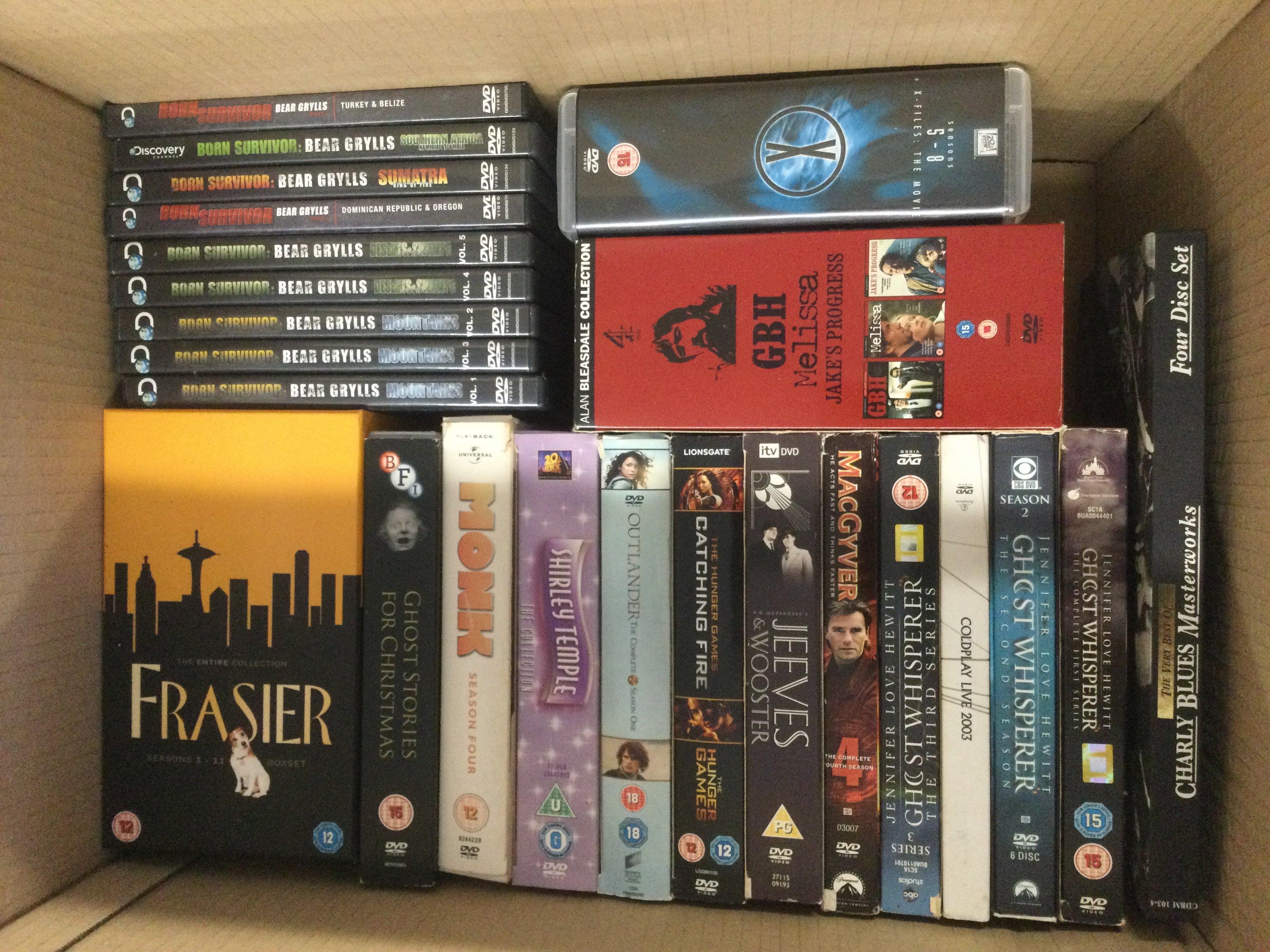 Four boxes of DVDs and CDs including various box sets.