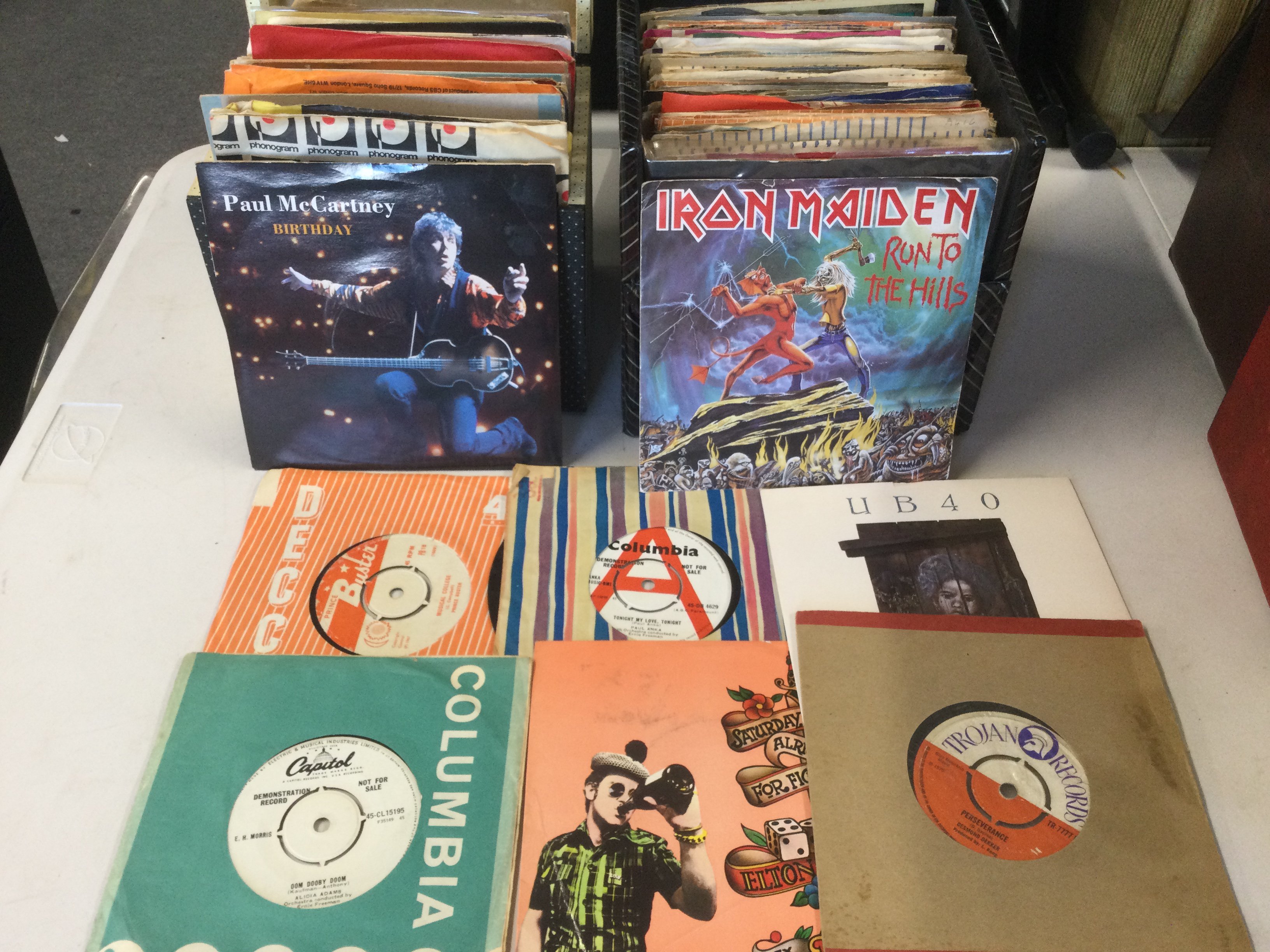 Ten record cases of 7" singles and EPs by various artists including The Beatles, Blur, The Jam, Black Sabbath and many more.