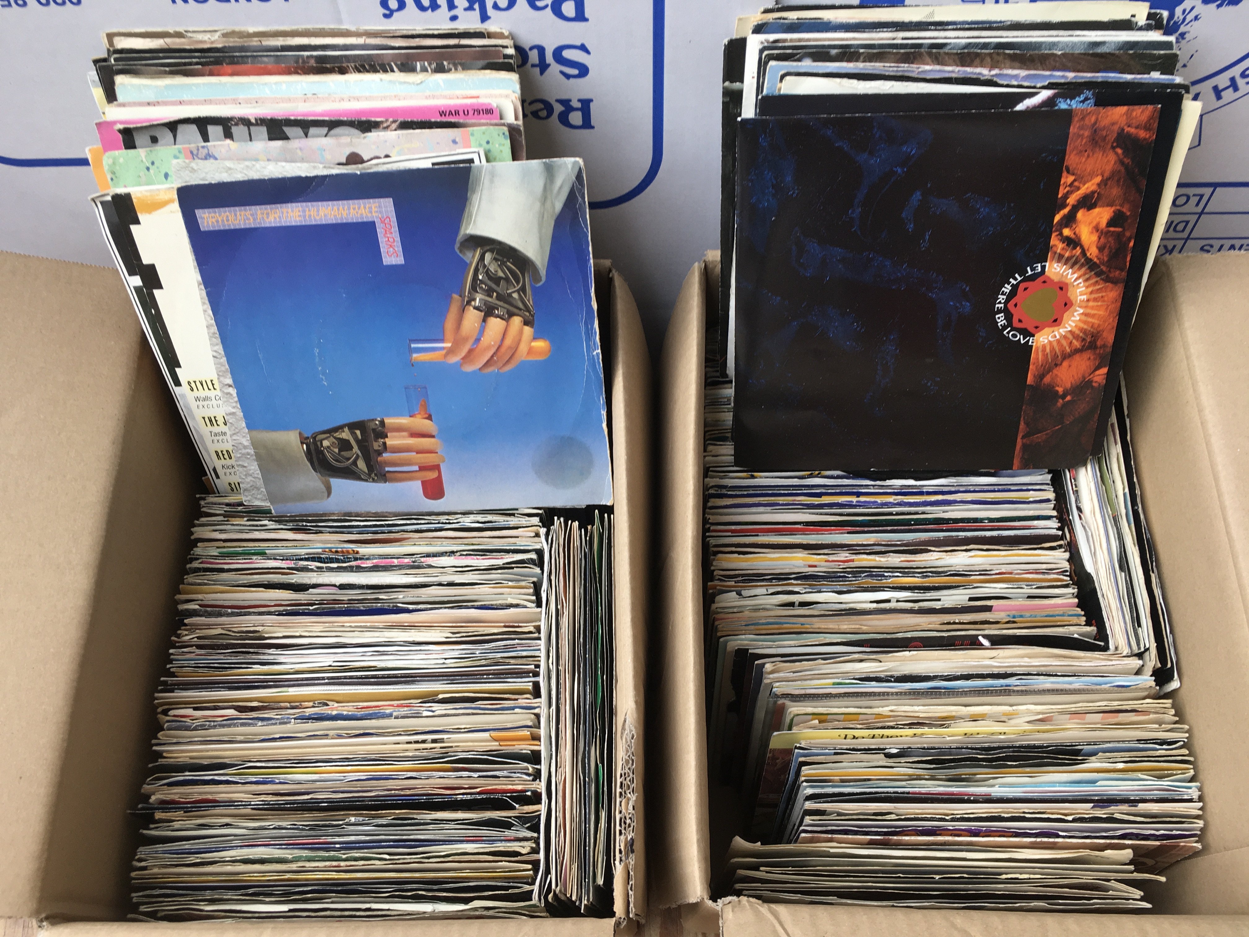 Four small boxes of 7" singles by various artists from the 1980s onwards.