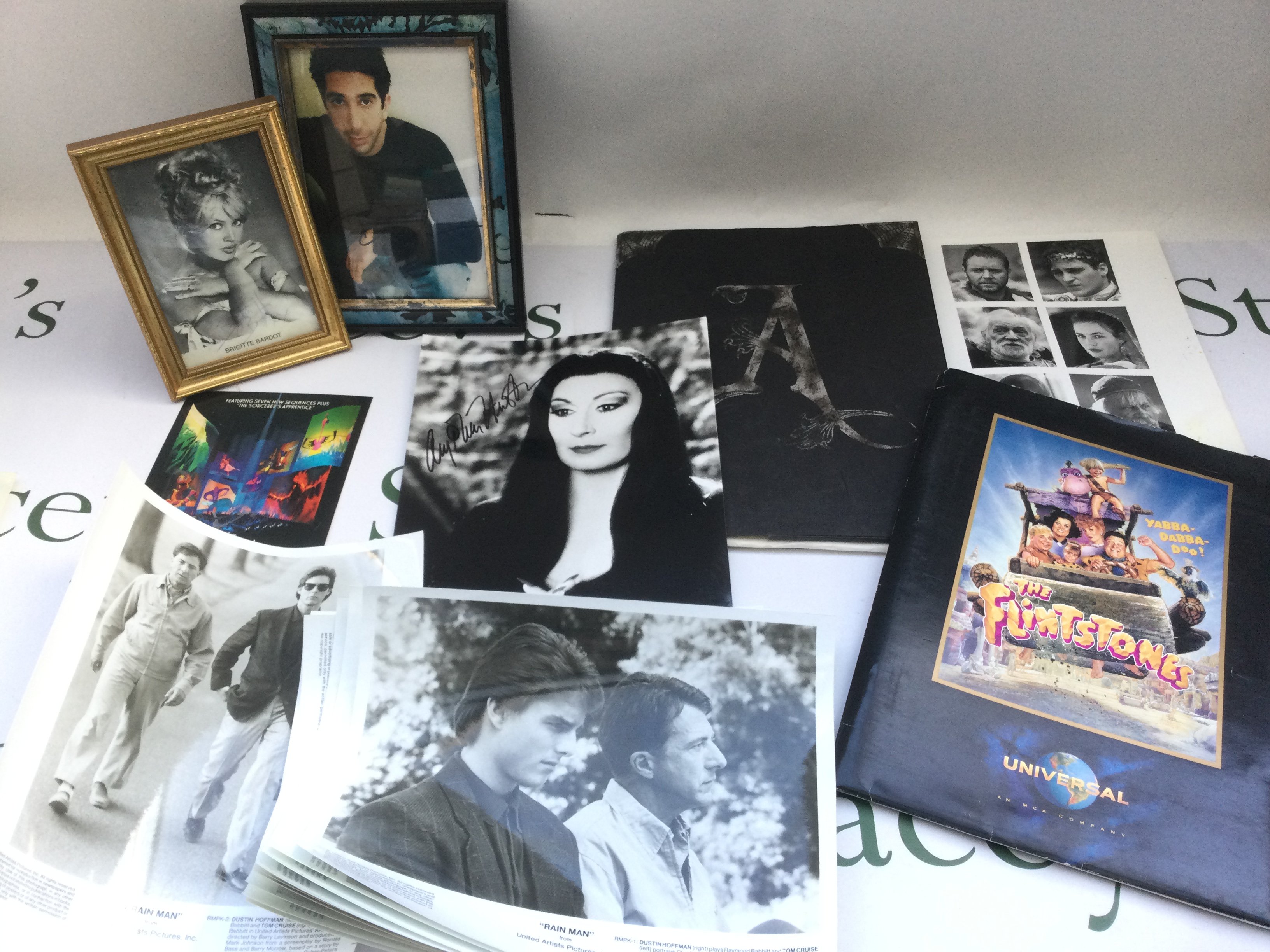 A collection of film memorabilia comprising Rain Man lobby cards, an Addams Family press pack with a signed Anjelica Houston photo, other signatures including Brigitte Bardot, David Schwimmer etc.