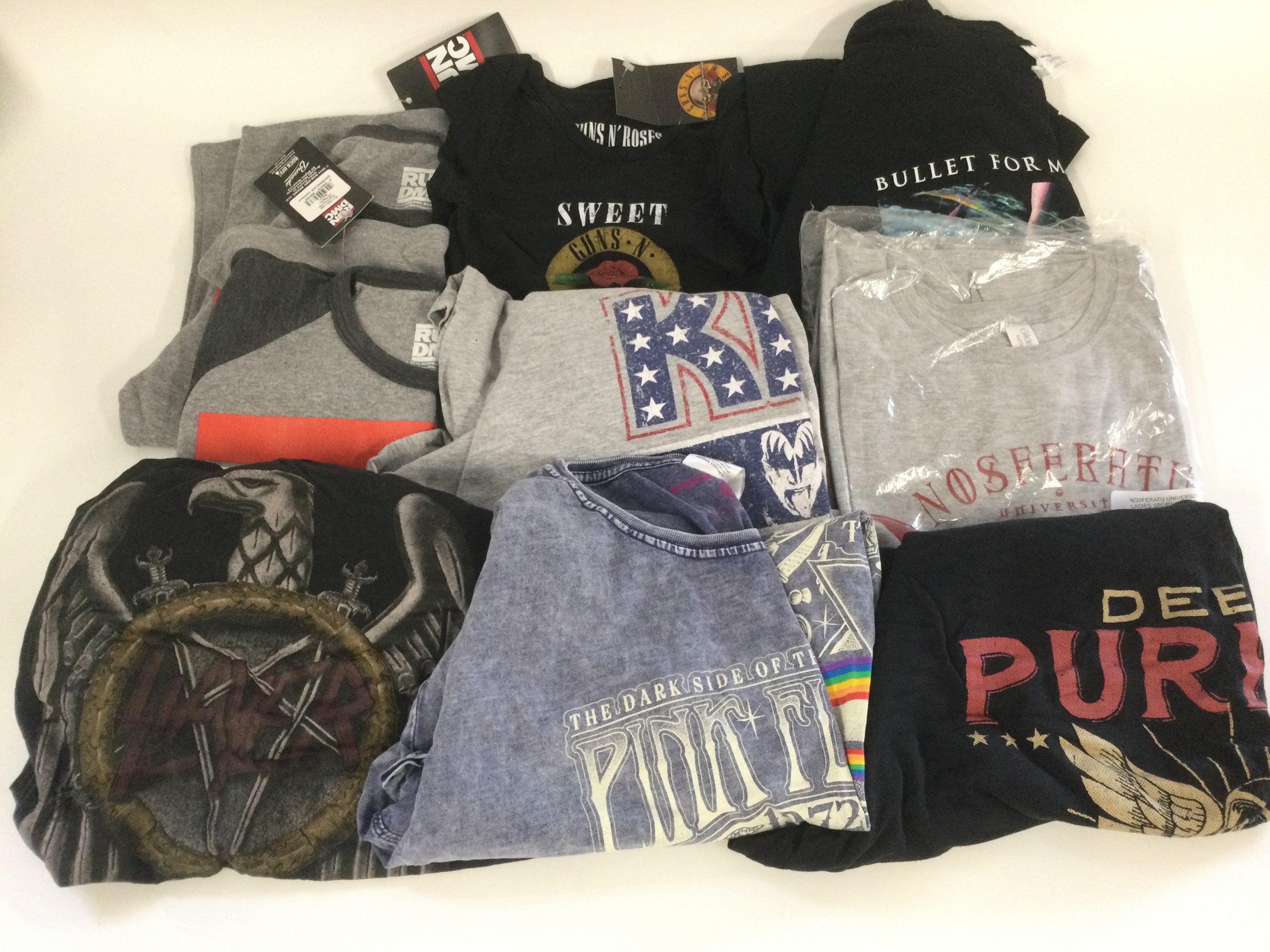 A collection of music T shirts for various acts including Deep Purple, Kiss, Pink Floyd and others plus a Guns n Roses baby grow.