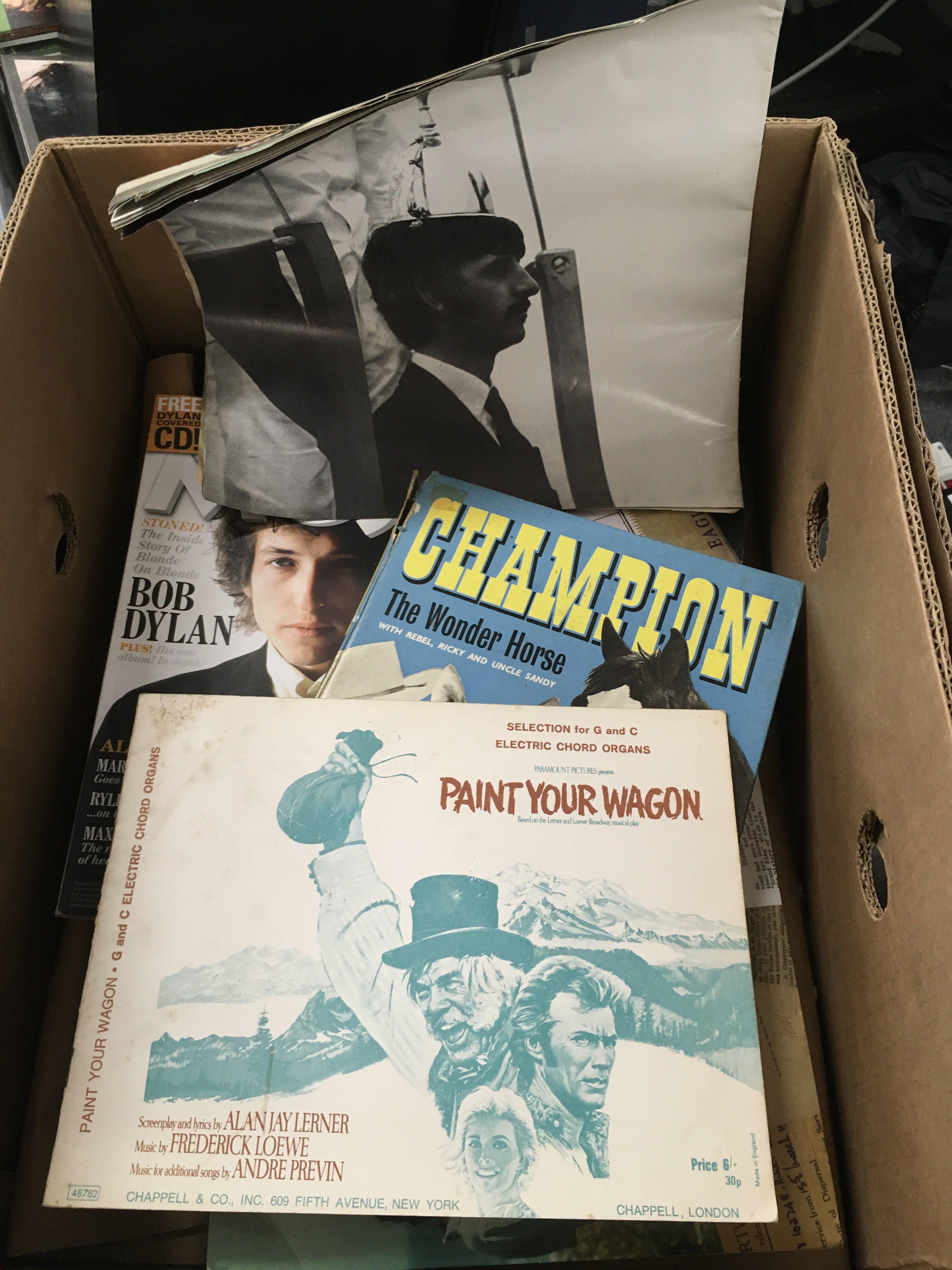 A box of music memorabilia comprising tour programs for Paul Weller (with tickets), Bruce Springsteen and others plus a Pink Floyd baseball cap, some Supertramp publicity prints, books etc.