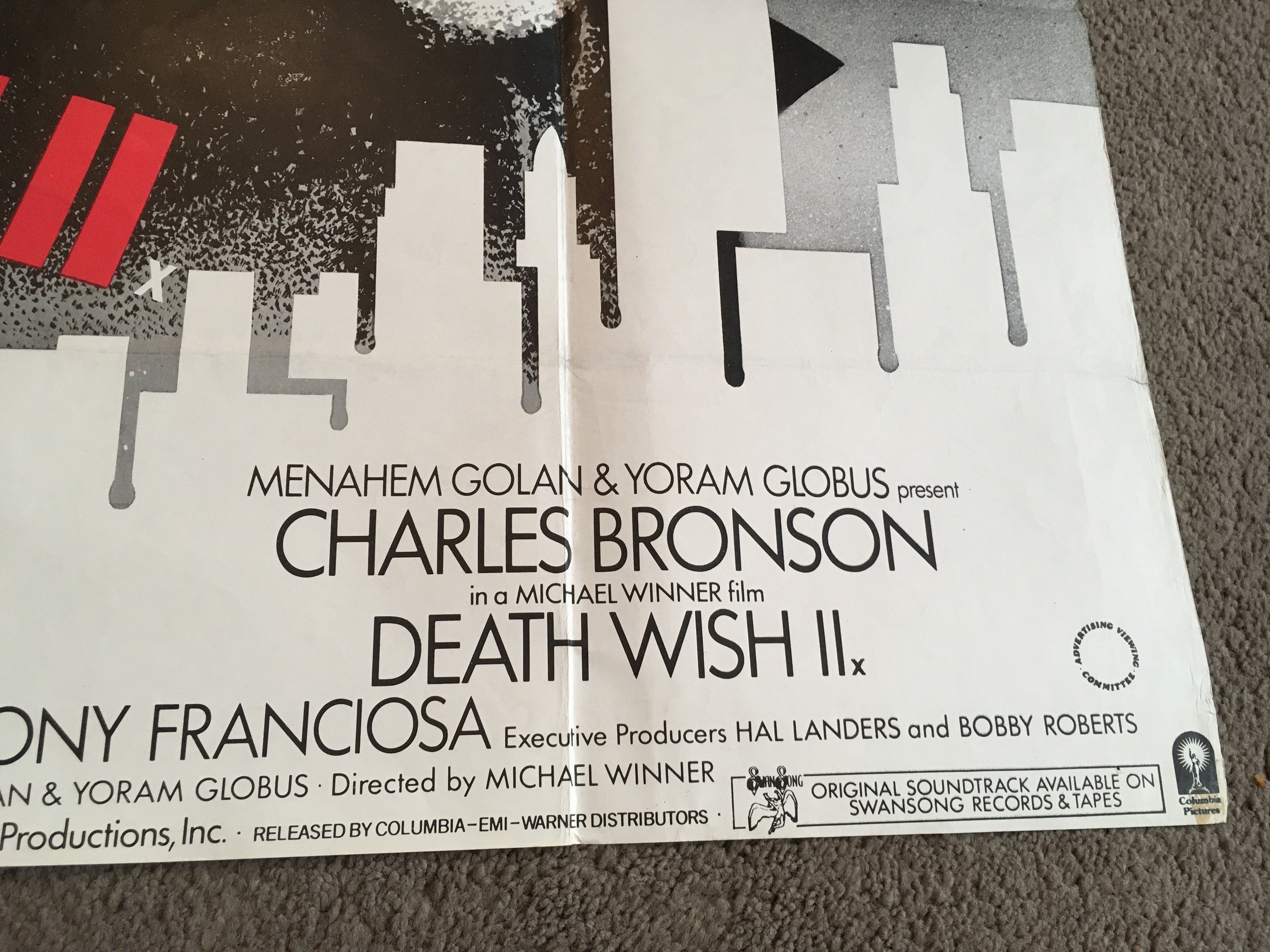 Two film posters comprising a UK quad film poster of 'Death Wish 2', folded with tears, sellotape marks, damage to corners, crude repairs approx 101cm x 76cm and A UK quad film poster for 'Assault On Precinct 13', folded with damage to top left corner, approx 101cm x 76cm.