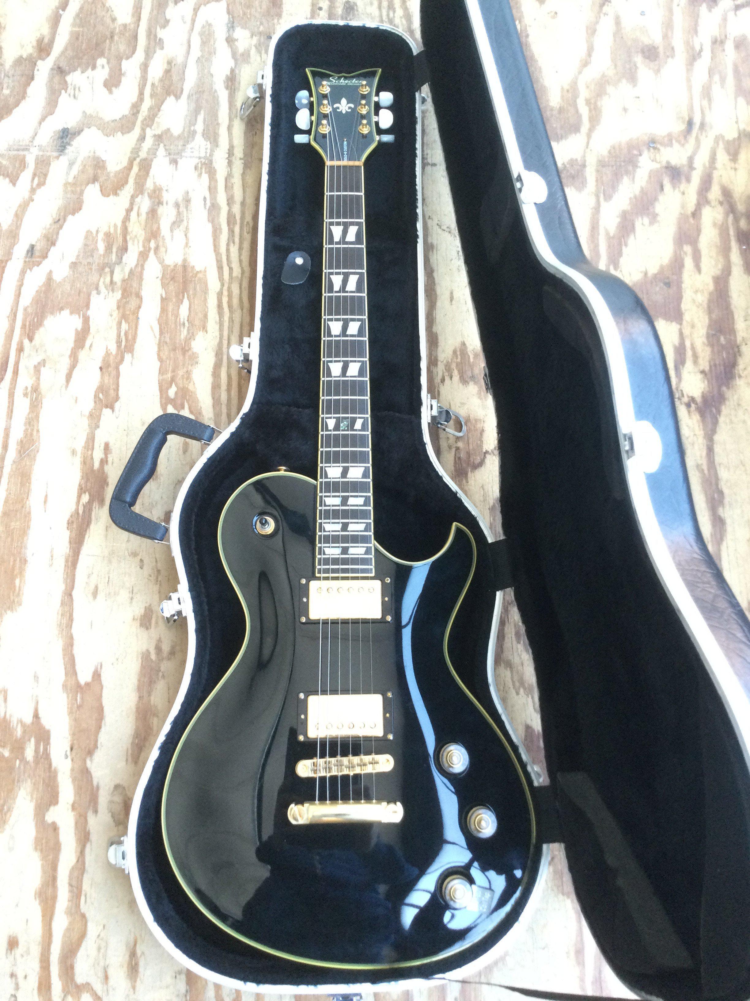 A Schecter Solo 6 Custom electric guitar with hard carry case.
