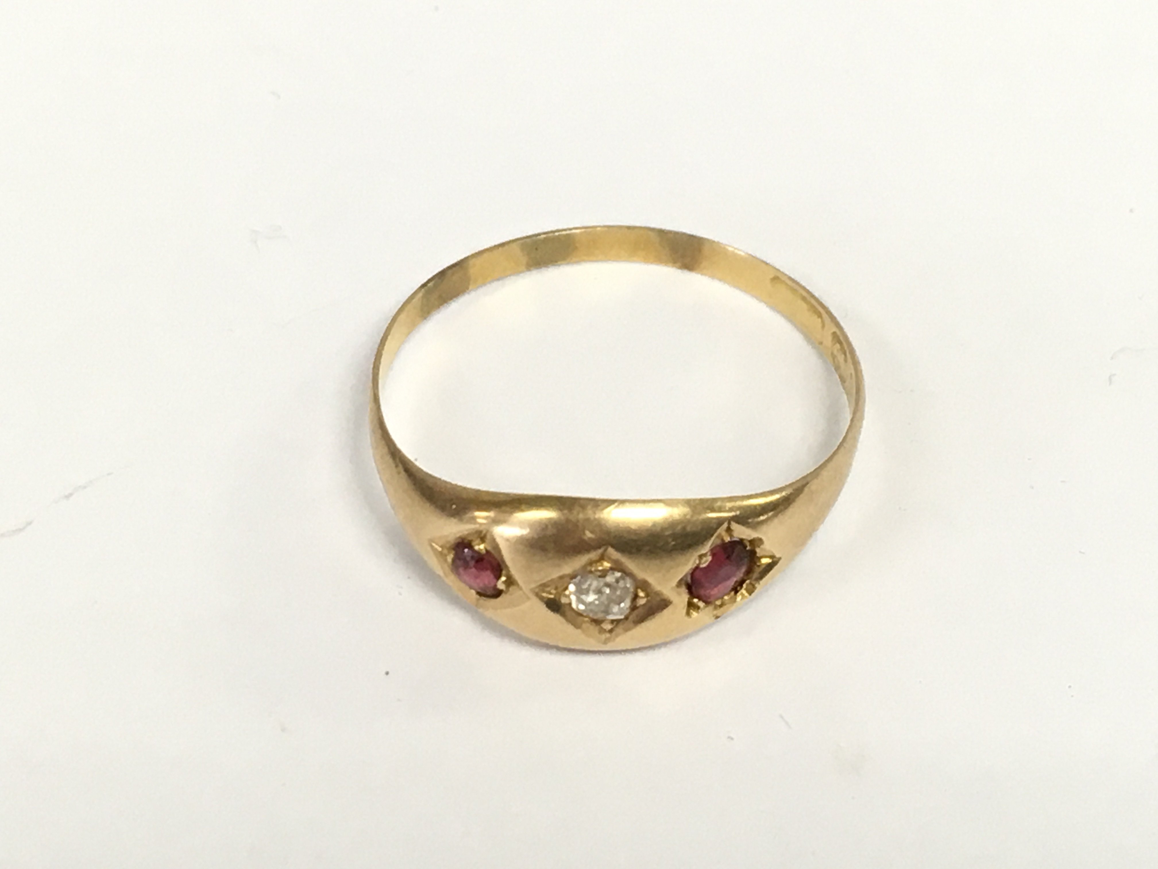 A gold ring set with small diamond and rubies. Approximately S 1/2 and 1.58g
