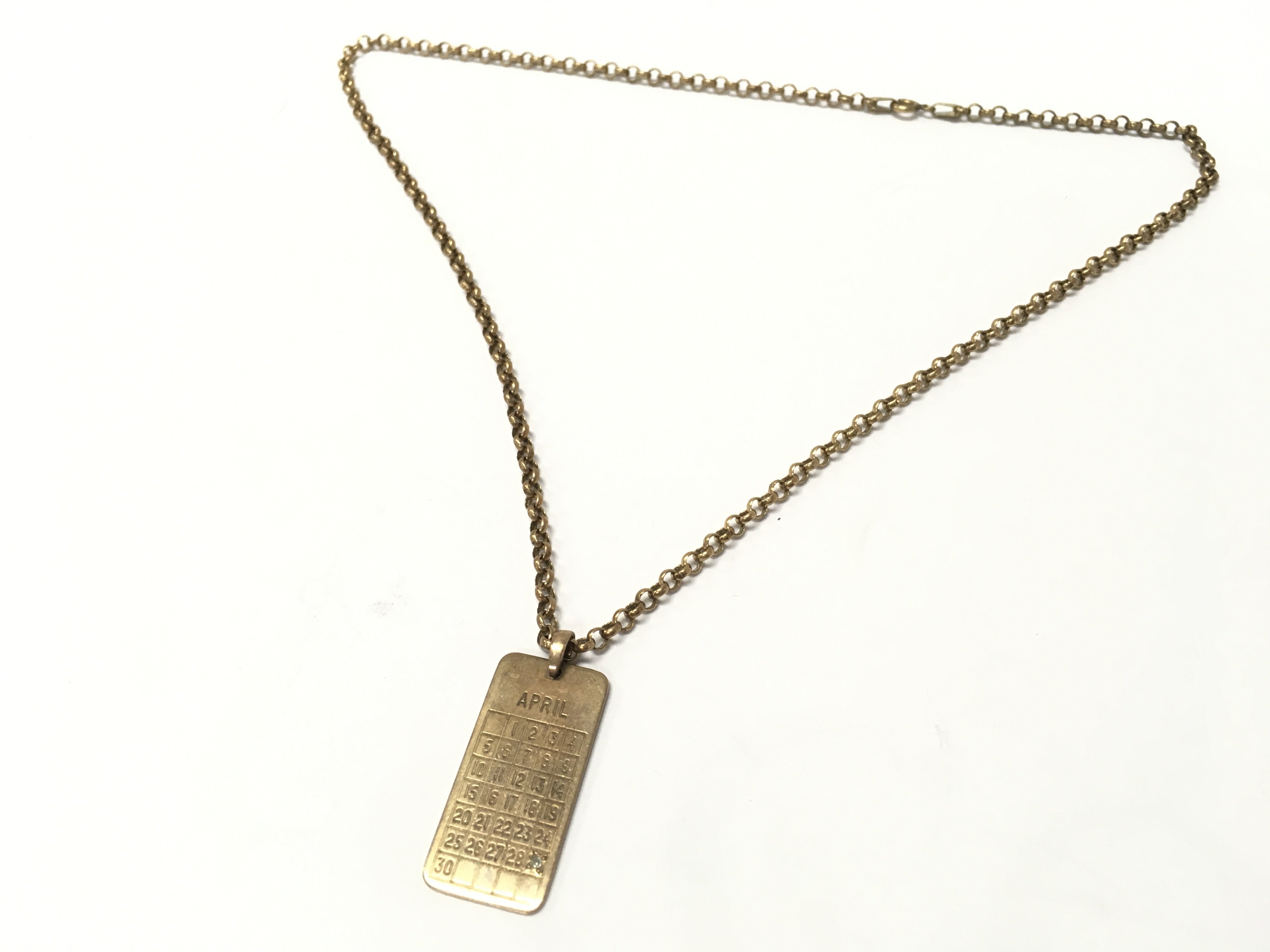 withdrawn - A 9ct gold chain and 9ct gold April 29th Calendar pendant . 10.1g total weight. Postage category A